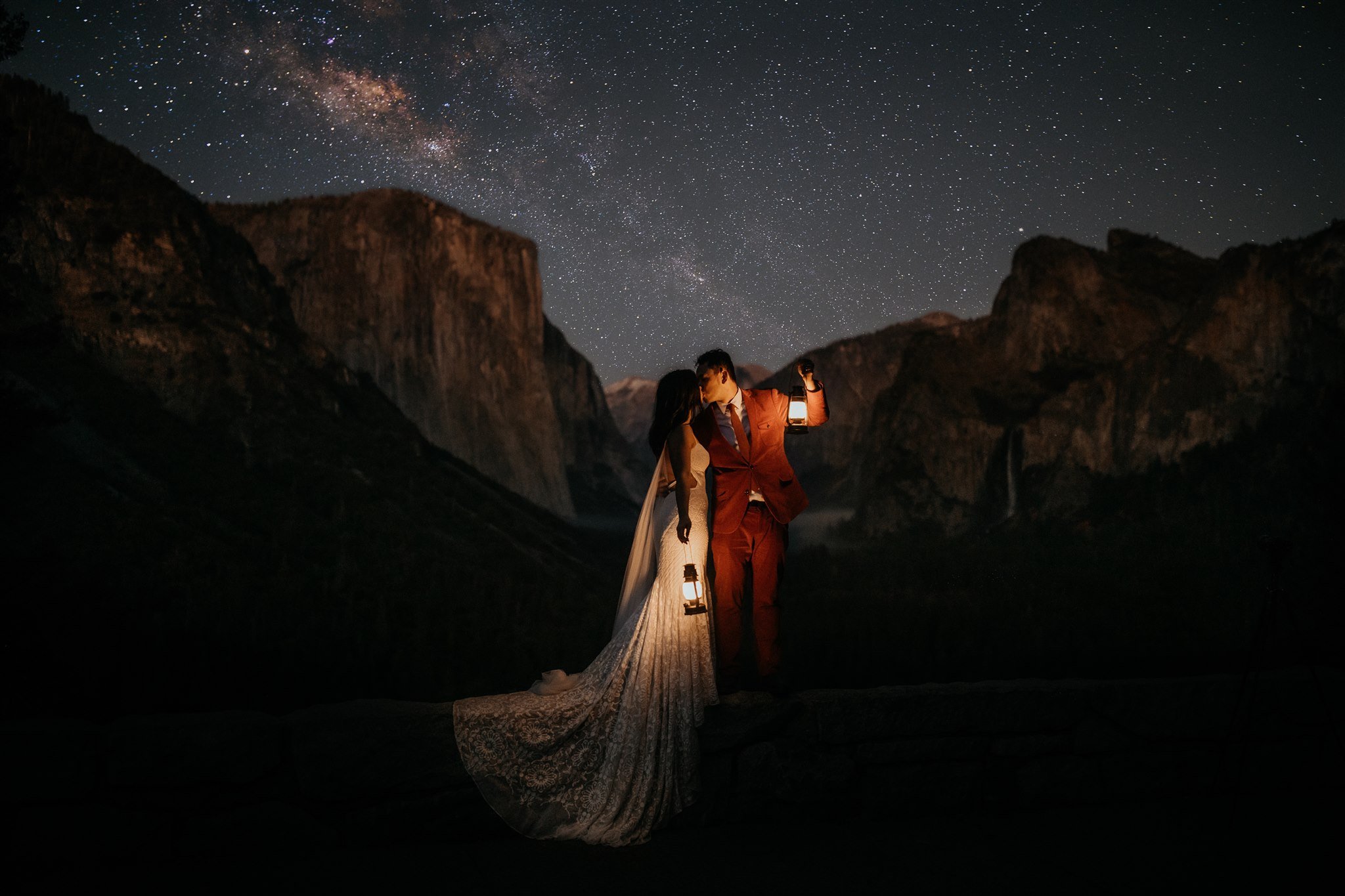 Bride and Groom hold lanterns and kiss at Tunnel View during their Yosemite elopement.