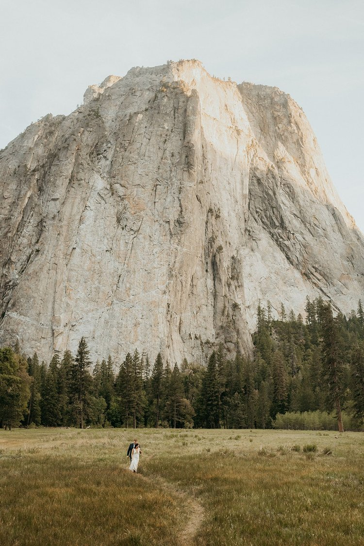 Bride and groom walk through a trail during their Yosemite California elopement in El Capitan meadow.