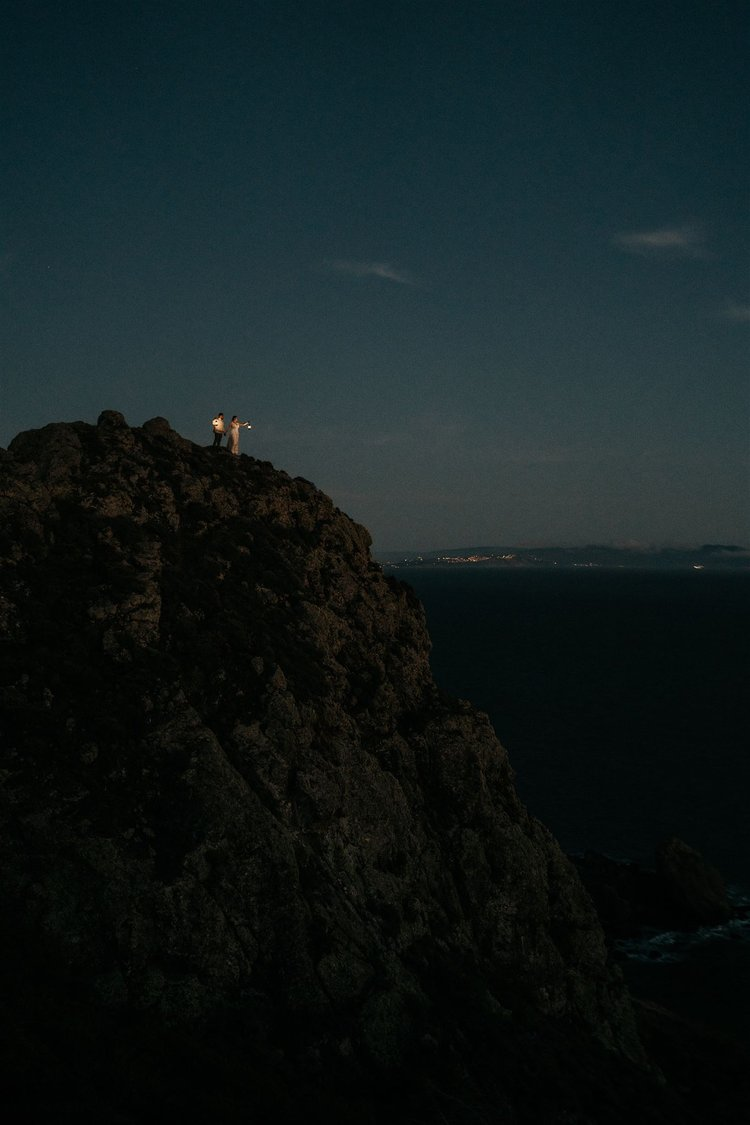 Bride and groom hold lanterns during their Marin Headlands, California elopement at blue hour.