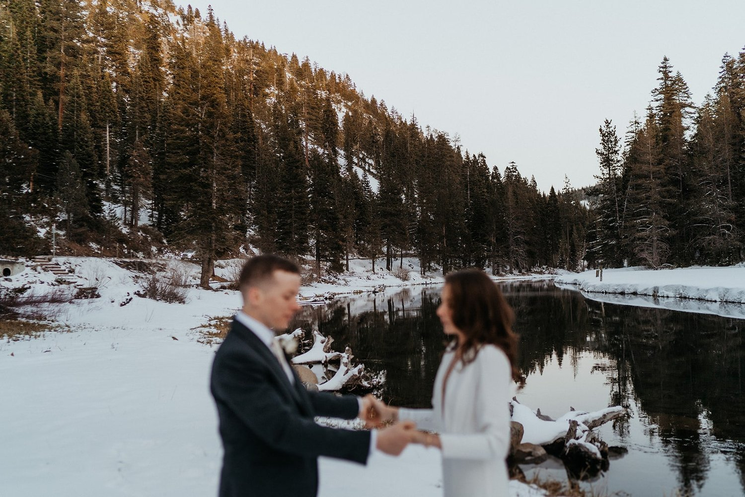 Bride and groom hold hands during their snowy Lake Tahoe, California elopement.