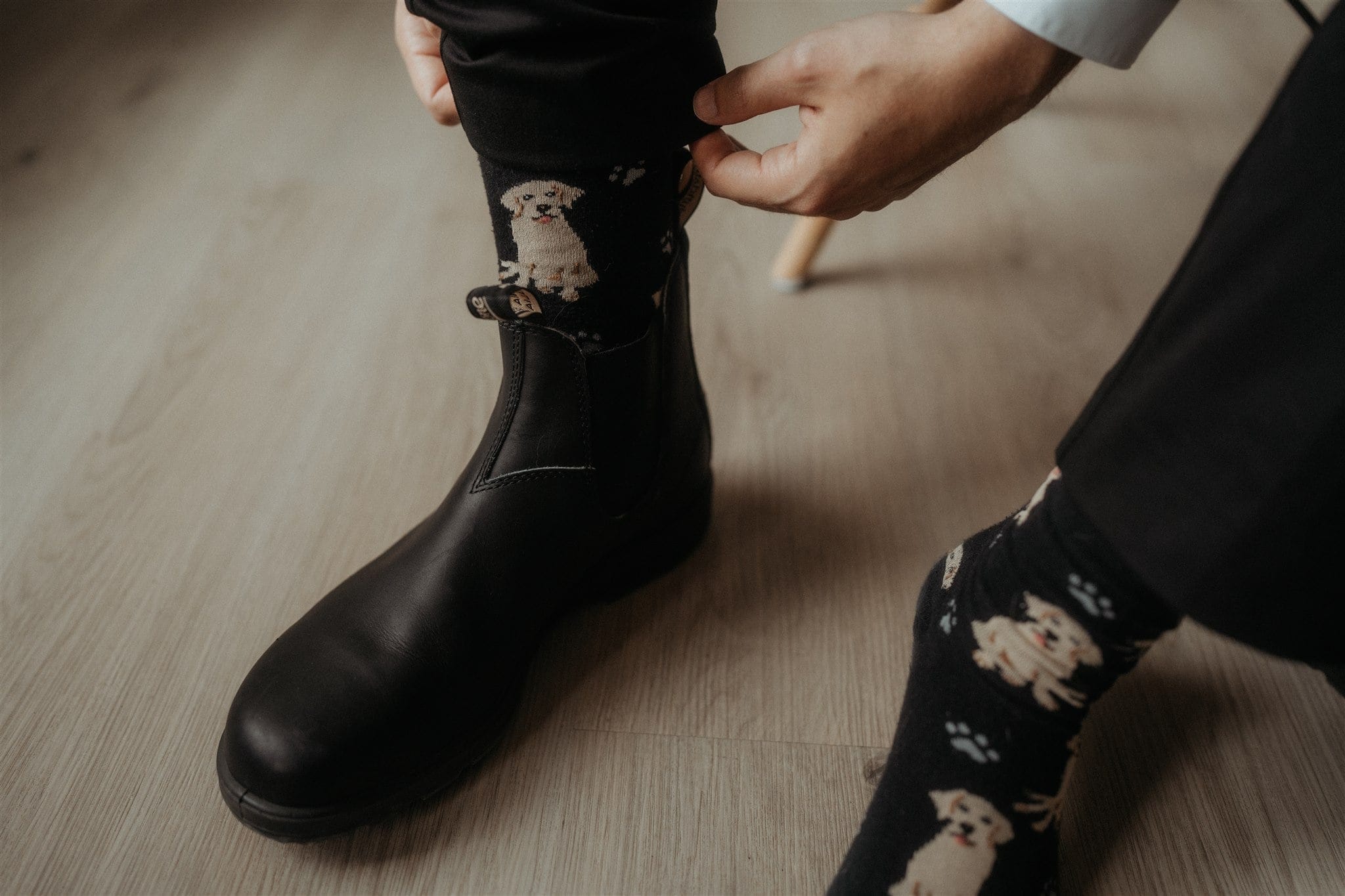 Groom adjusts socks with dogs on them