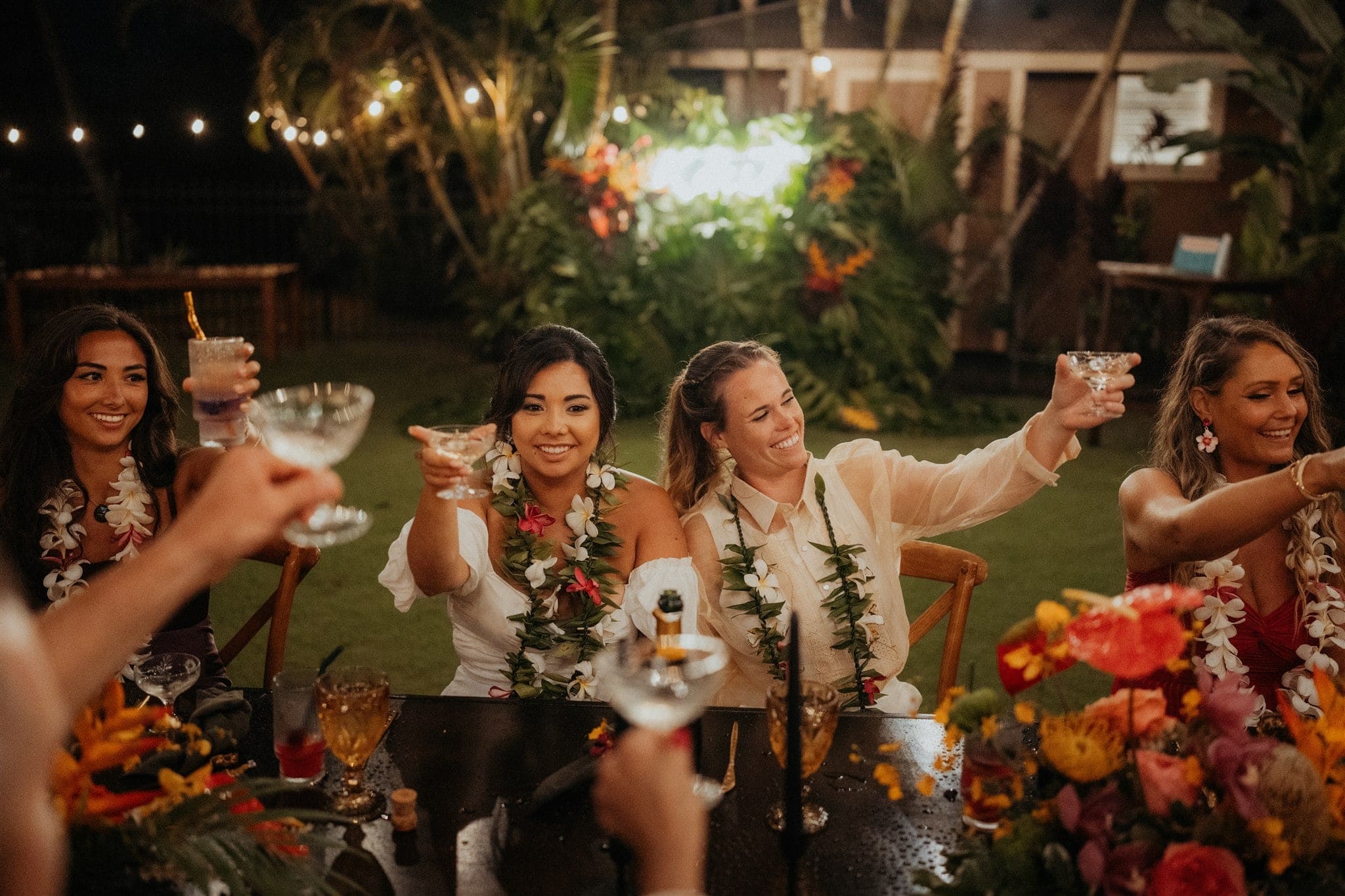 Brides toast guests at their elopement reception in Hawaii