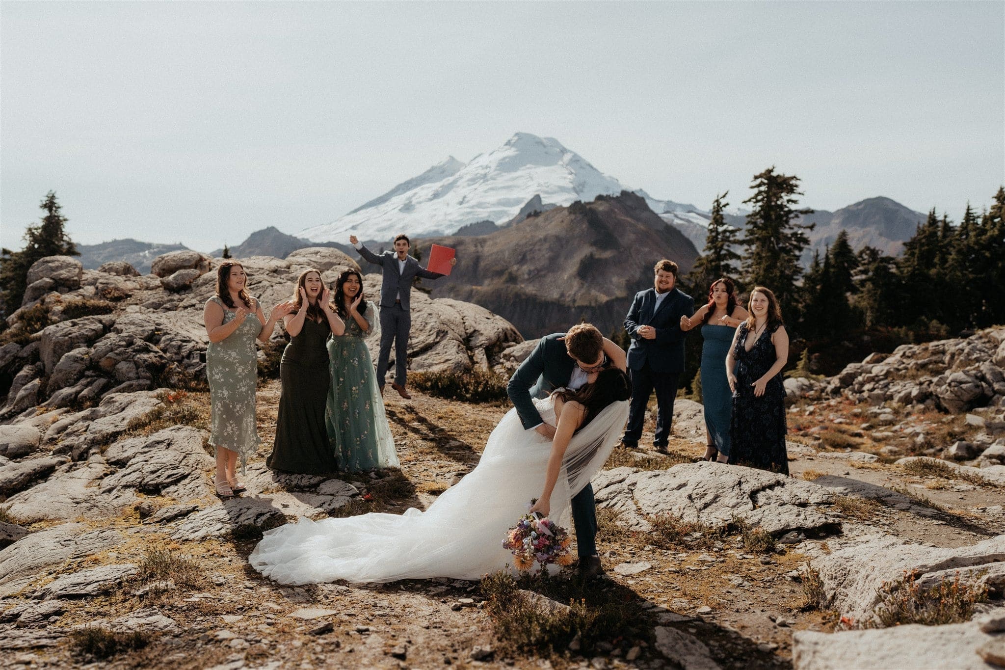 Groom dips bride for a kiss during their elopement ceremony in the mountains
