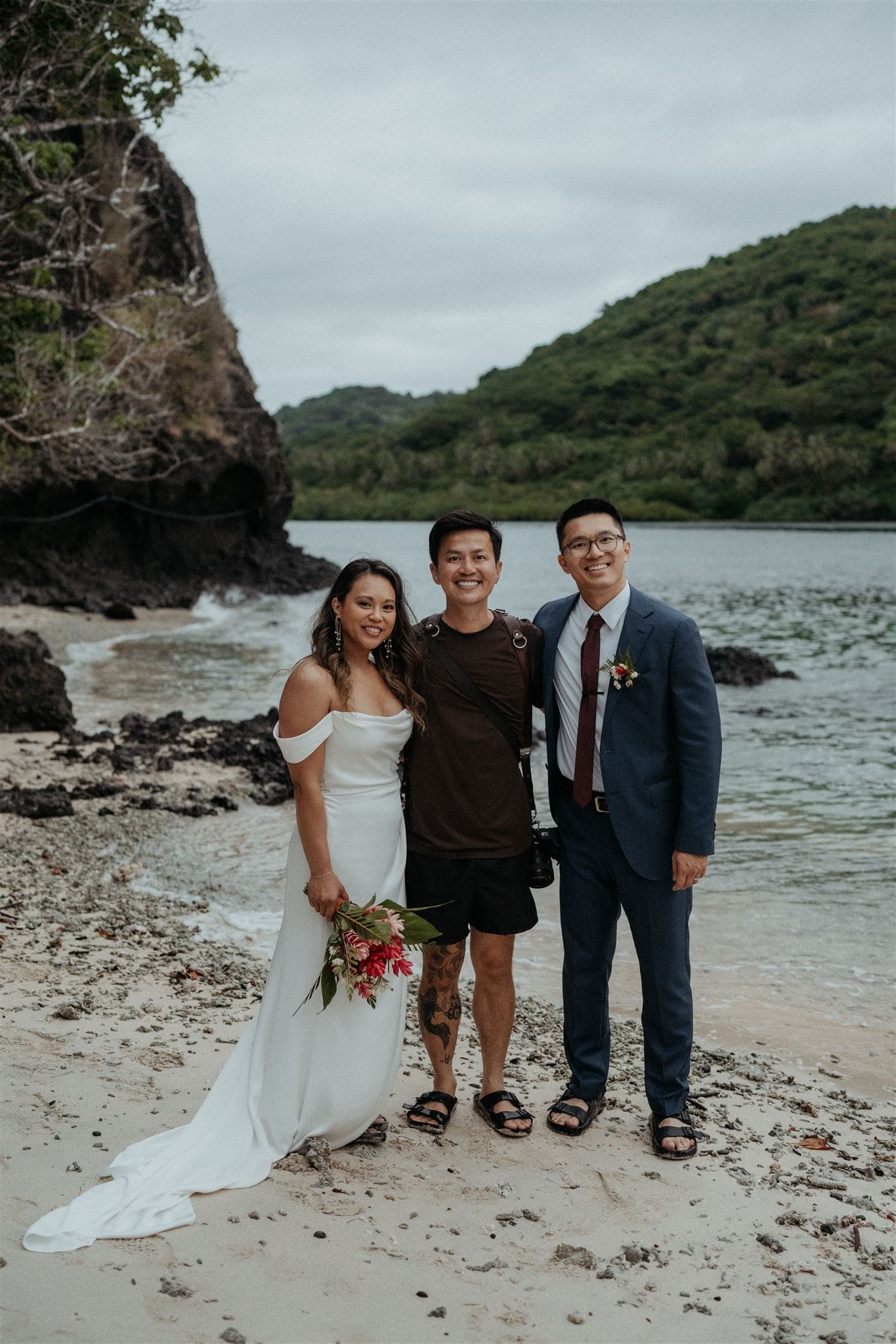 Bride and groom pose on a beach with their Fiji elopement photographer