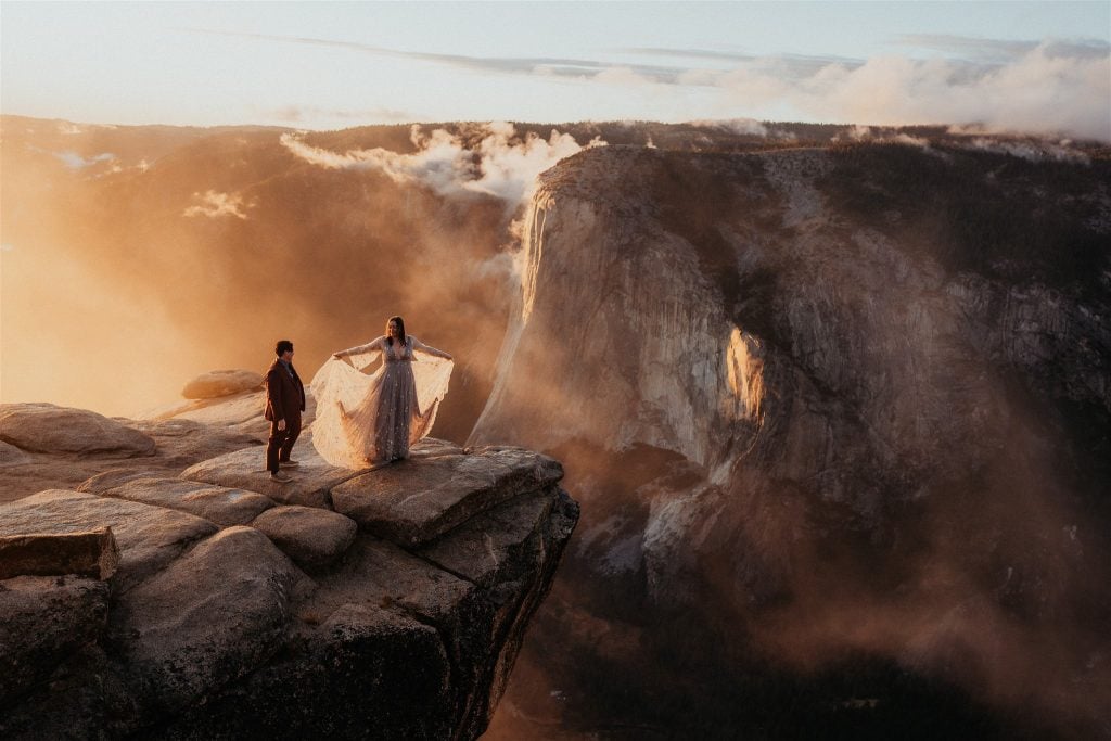 newlyweds dancing on taft point with the valley in the background at sunset during their Yosemite micro wedding.