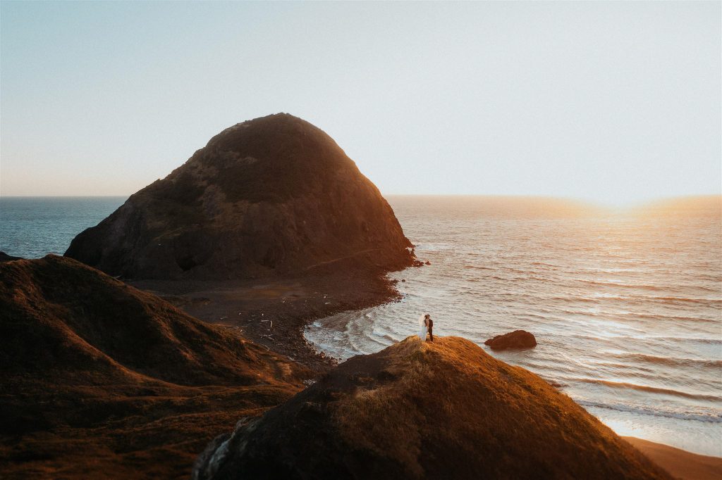 the couple kissing with the Oregon Coast in the background during their micro wedding.