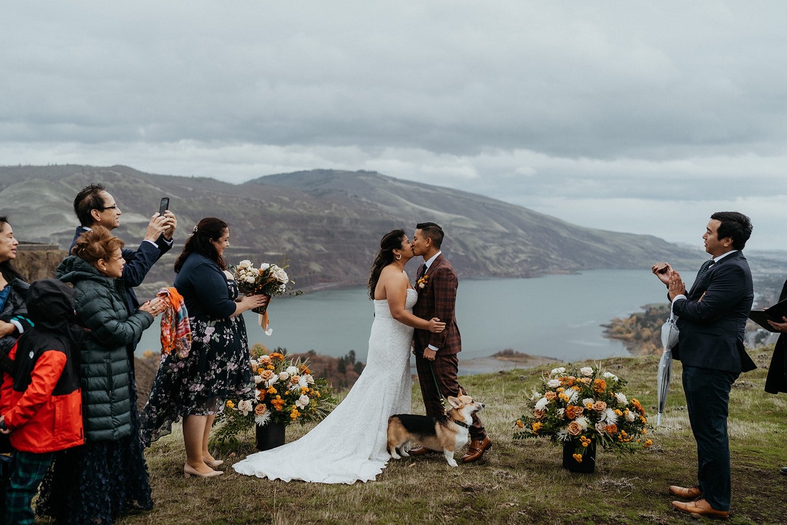 Bride and groom kiss while guests clap during their Columbia River Gorge elopement.