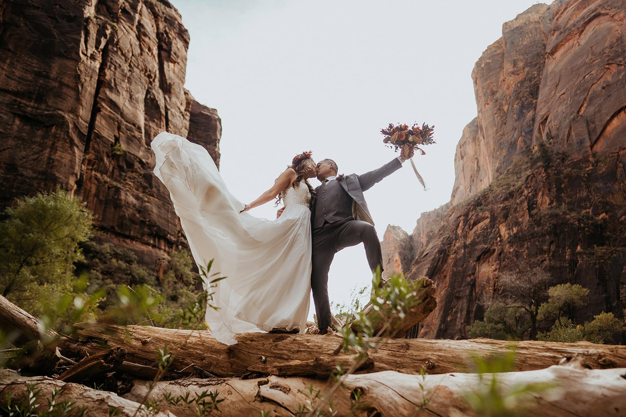 newlyweds kissing in a desert canyon. 
