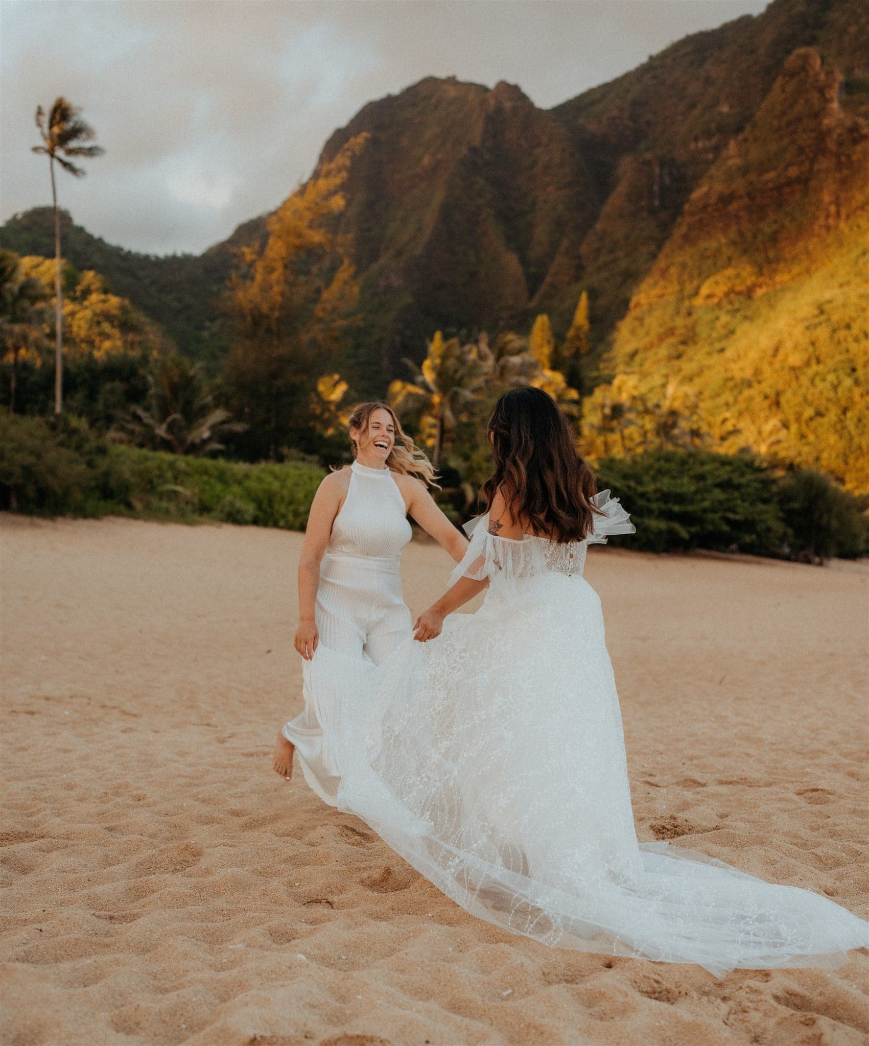 Brides dance on Tunnels Beach in Kauai during sunrise.