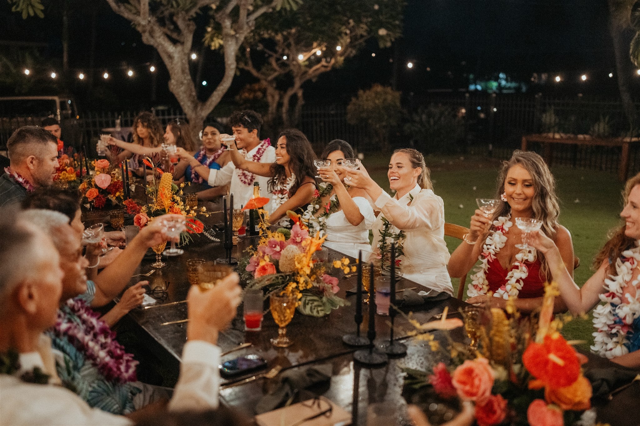 Guests toast at a Kauai micro wedding reception in a backyard.