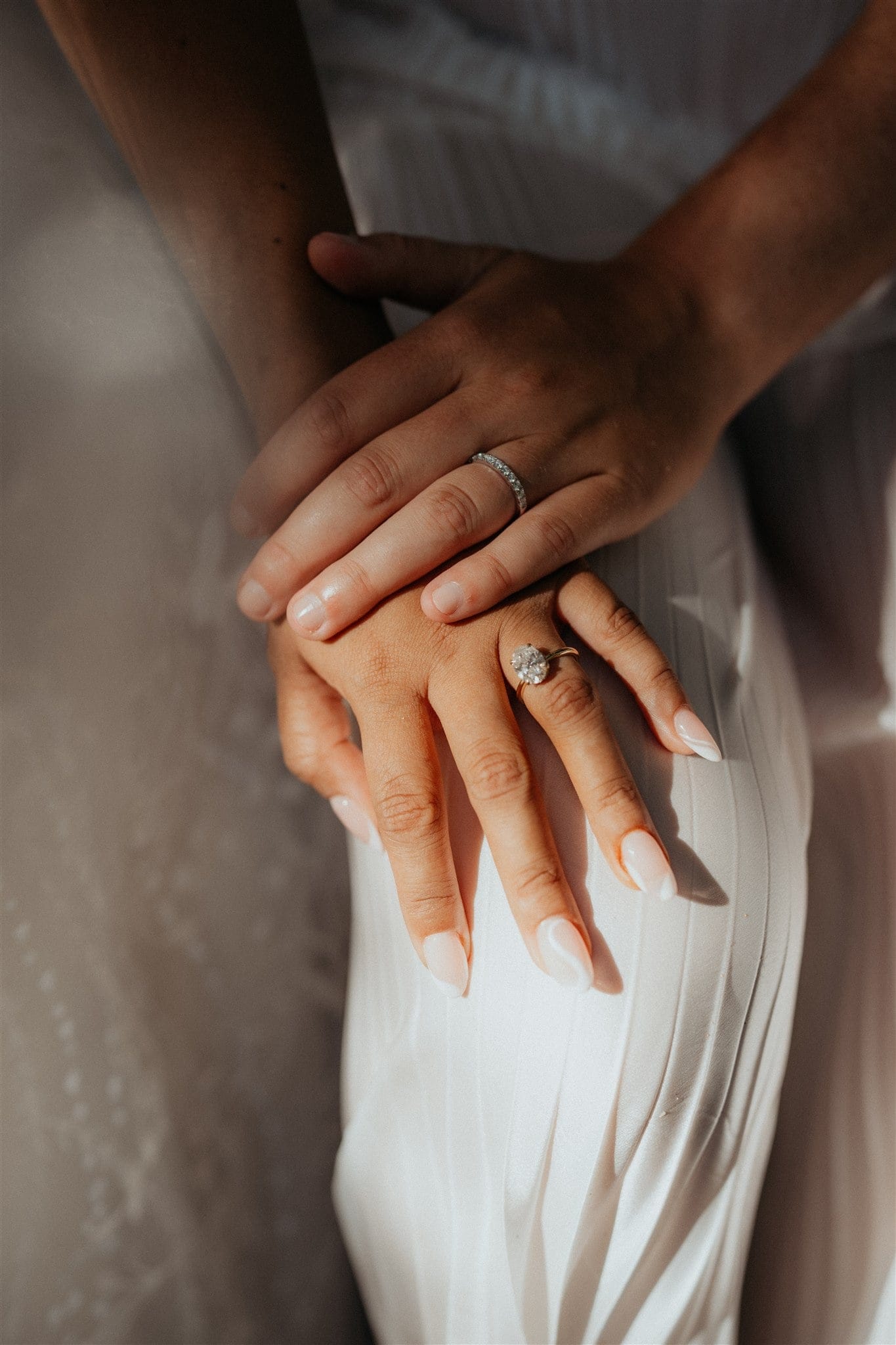 Brides rest their hands on top of each other.