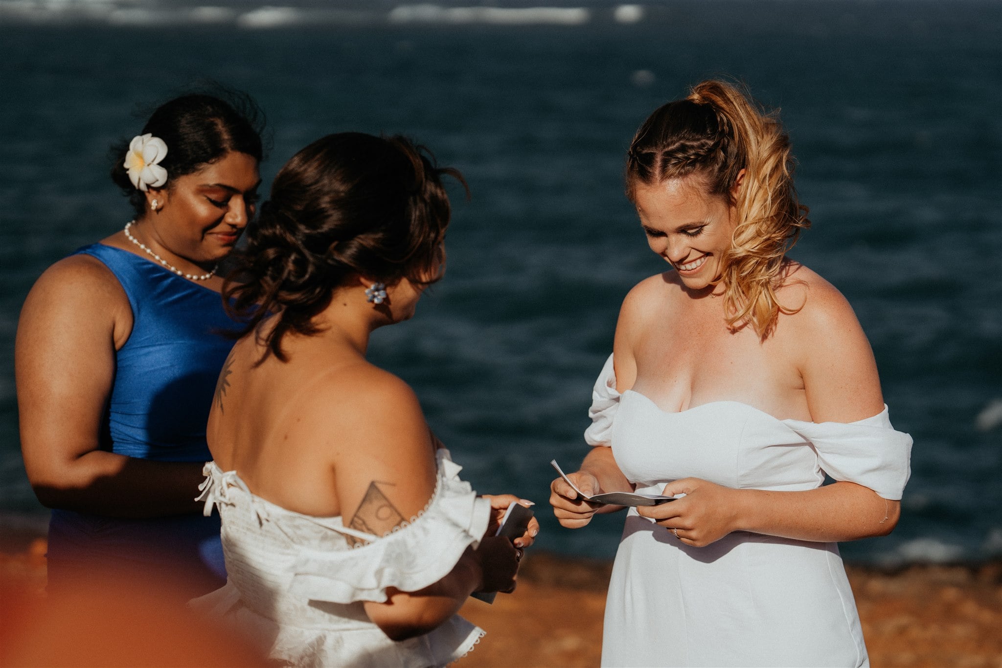 Bride smiles as she reads her personal vows during her Kauai micro wedding by the ocean.