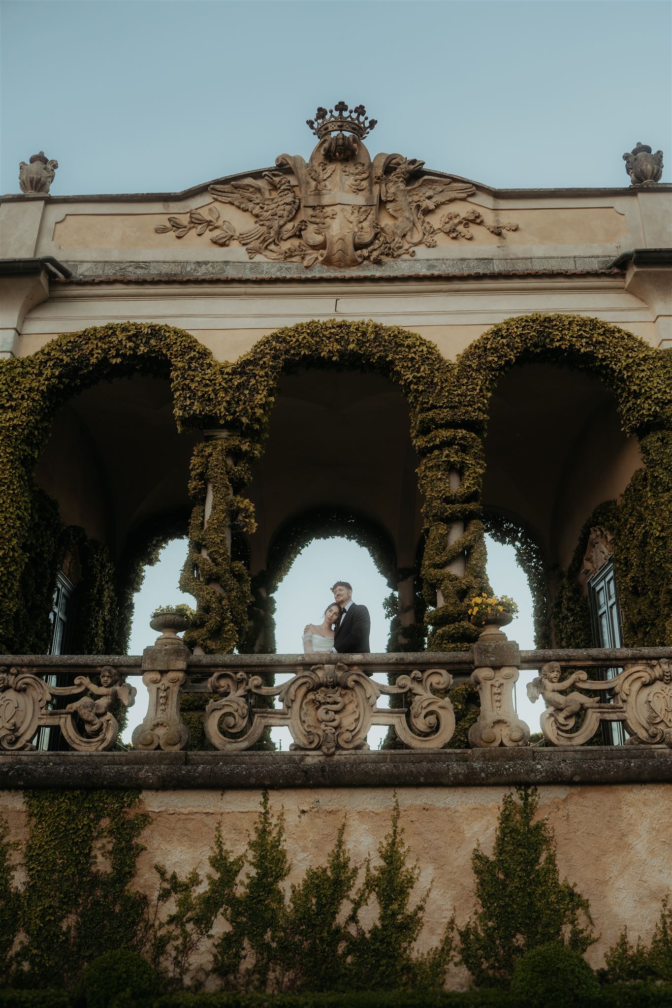Bride and groom stand on top of a balcony at a villa in Lake Como, Italy.
