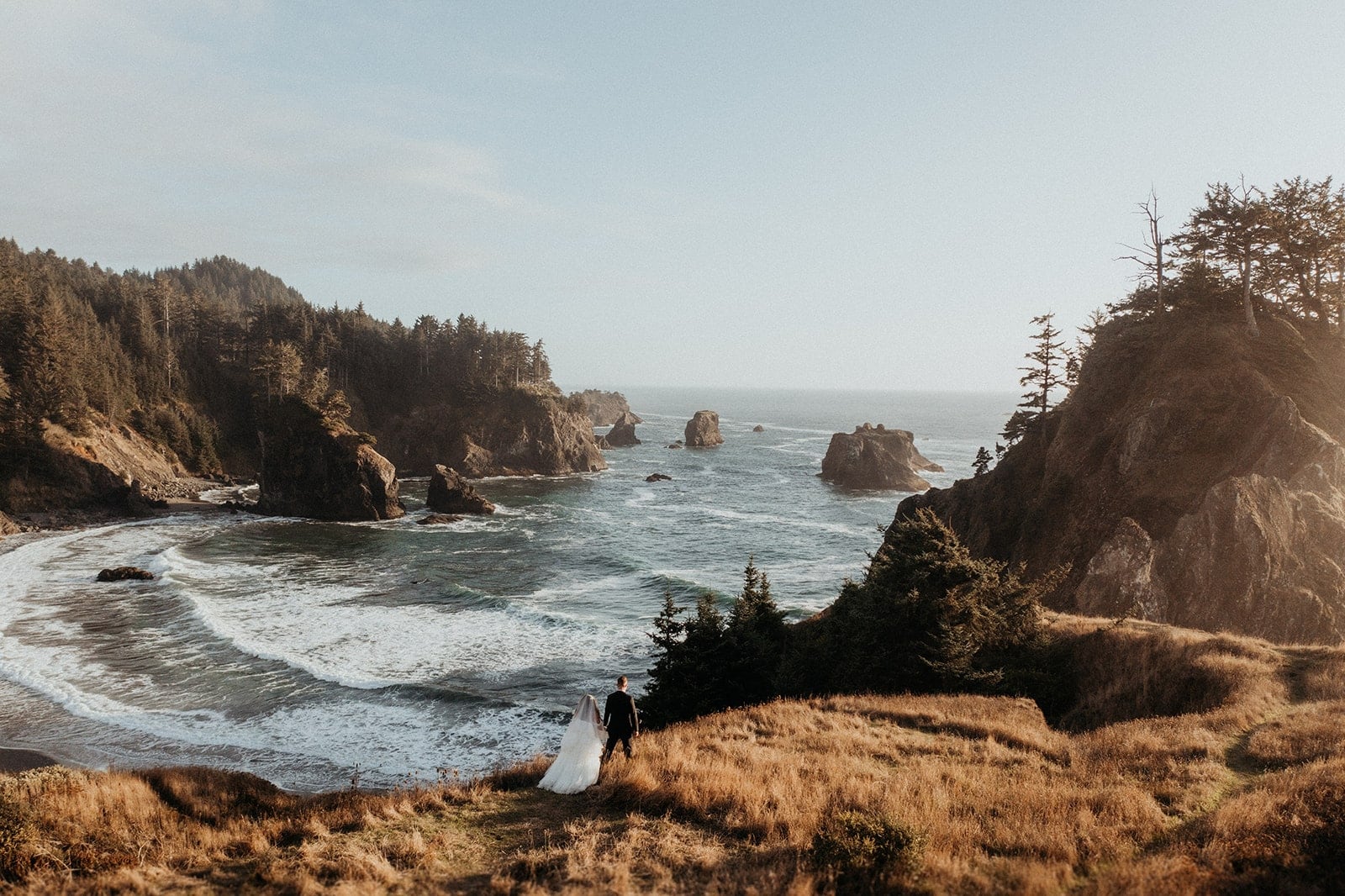 Bride and groom stroll around an overlook during their Oregon Coast multi day wedding.