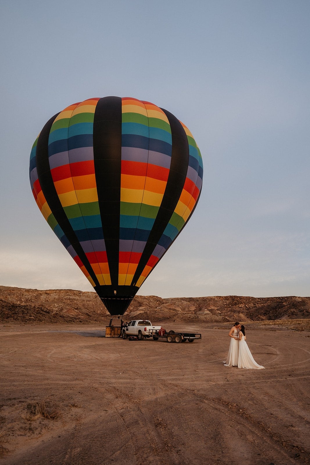 Brides hut and look at a colorful hot air balloon preparing for takeoff in the Moab desert.