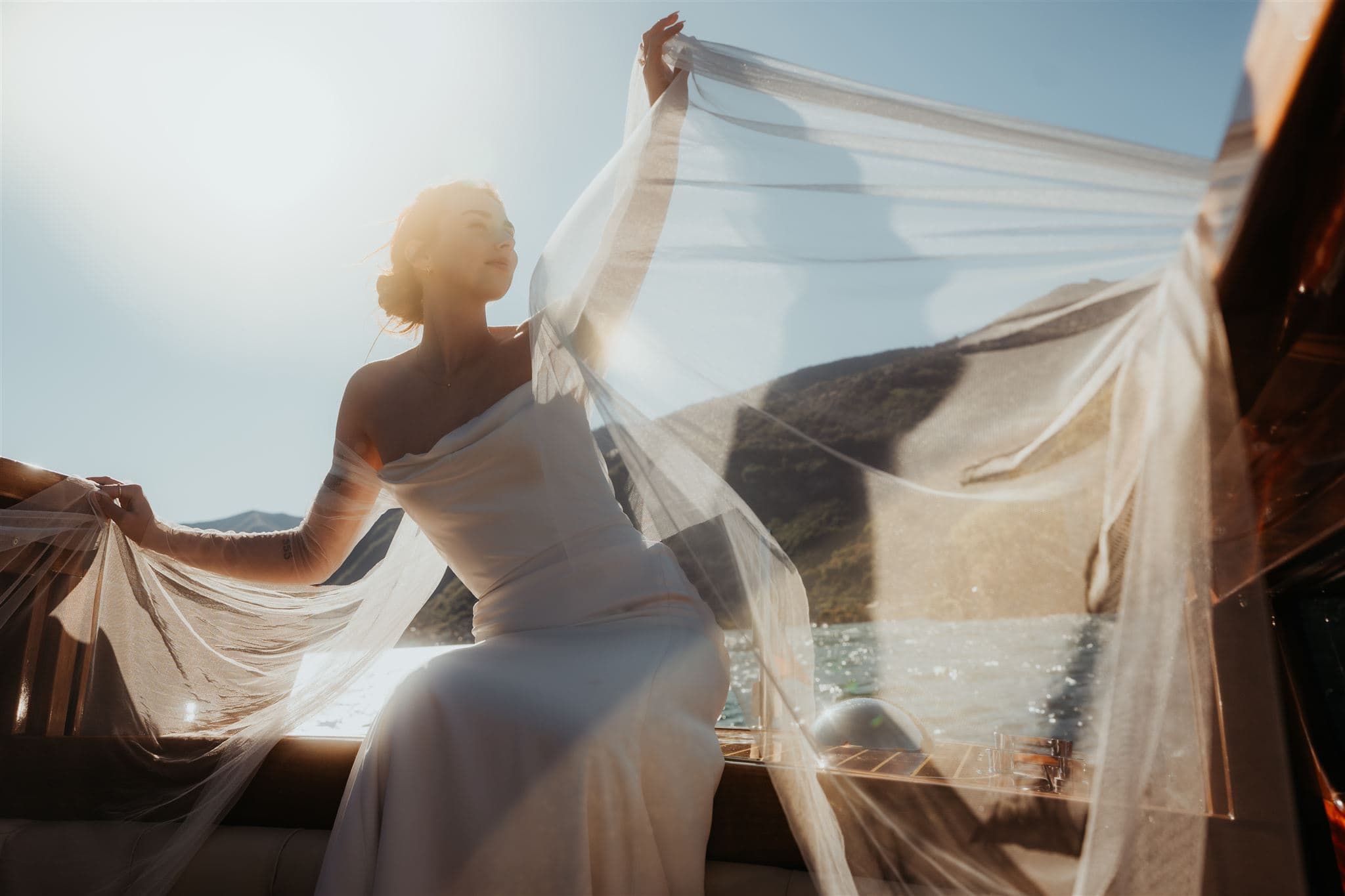 Bride's veil flies in the wind while riding a boat around Lake Como, Italy during her wedding weekend.