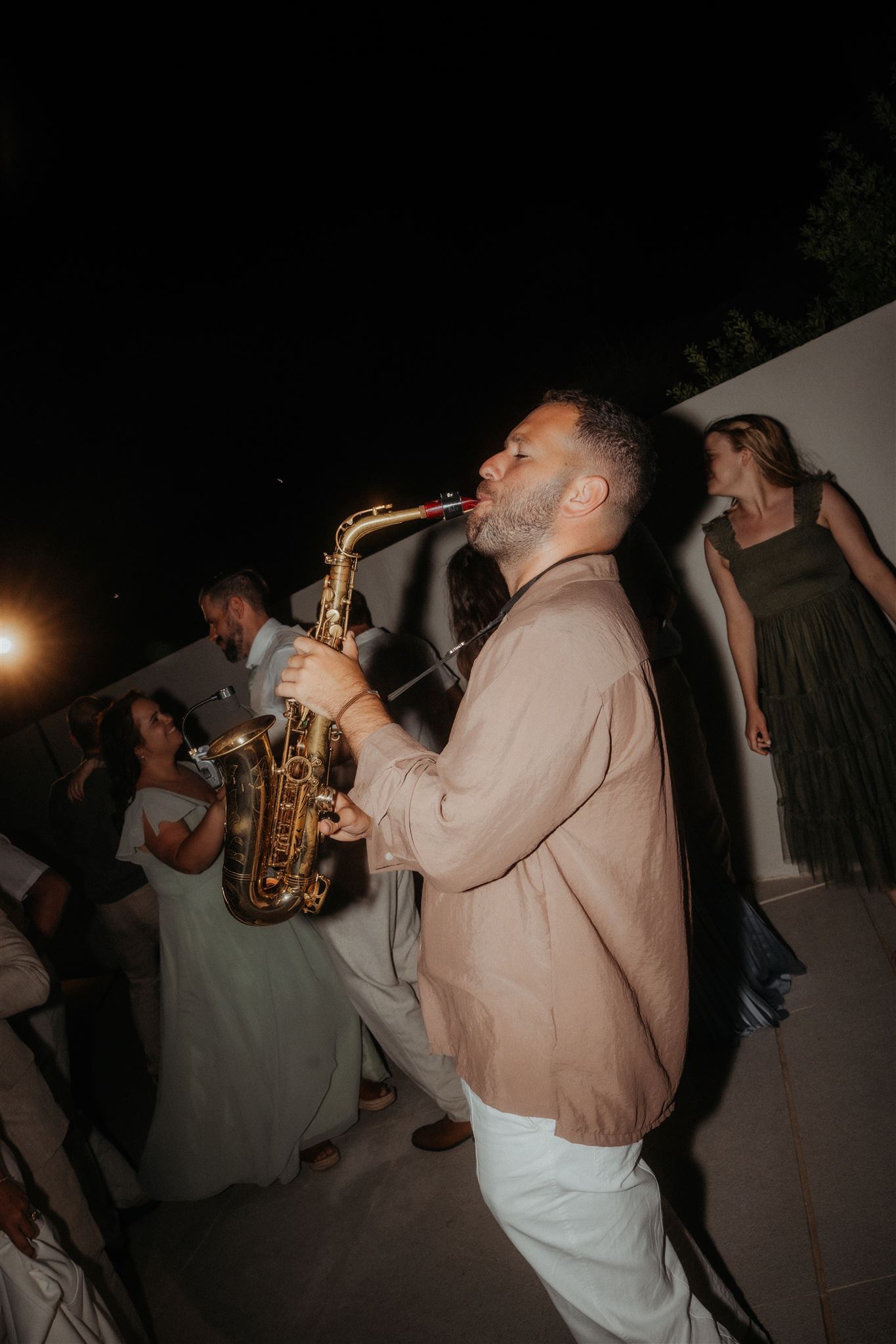 Live saxophonist plays during a wedding weekend reception dance floor.