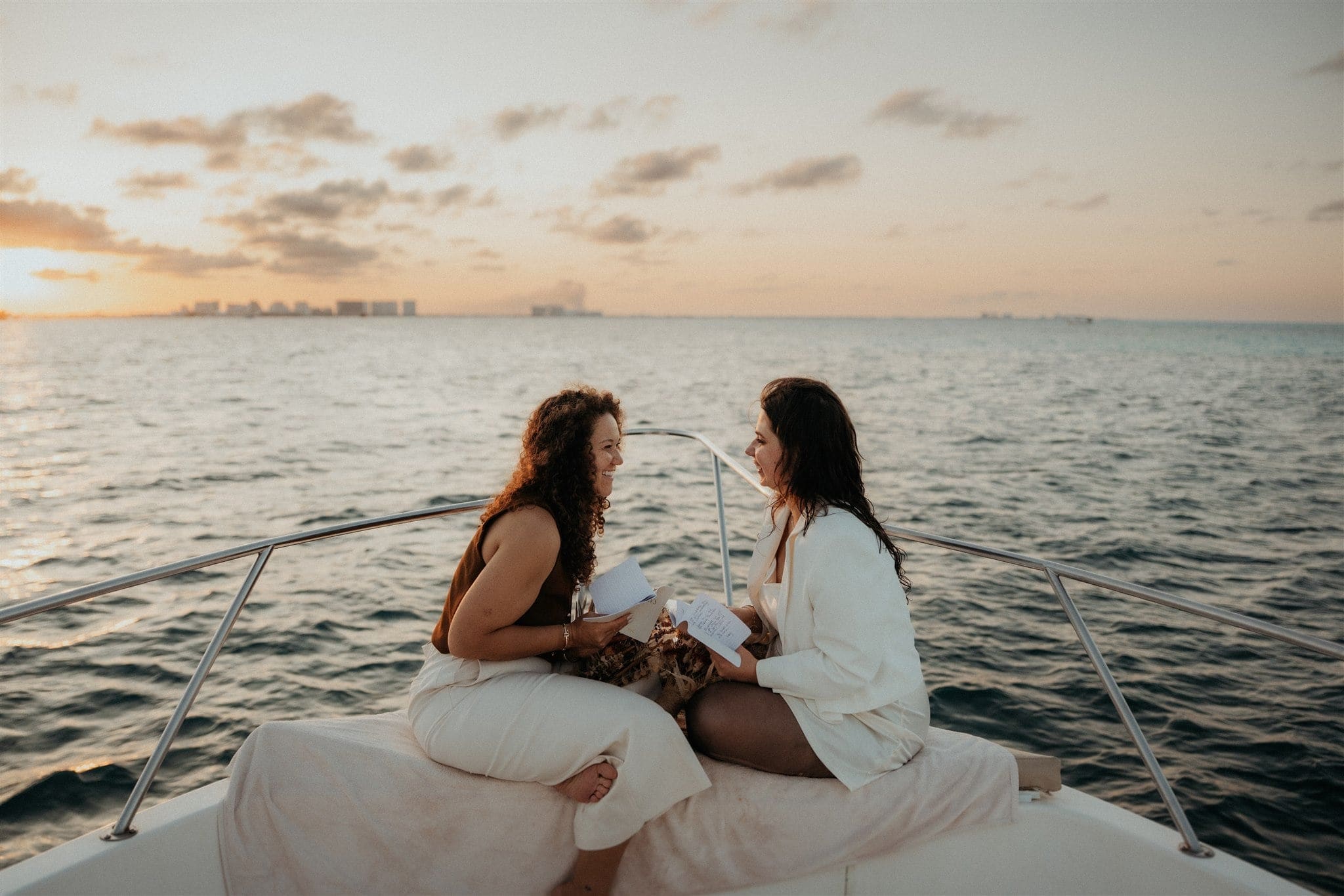 Brides exchange vows at sunset during their Cancun Mexico elopement on a boat.