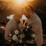 Grooms touch foreheads during their fire lookout elopement at sunrise.