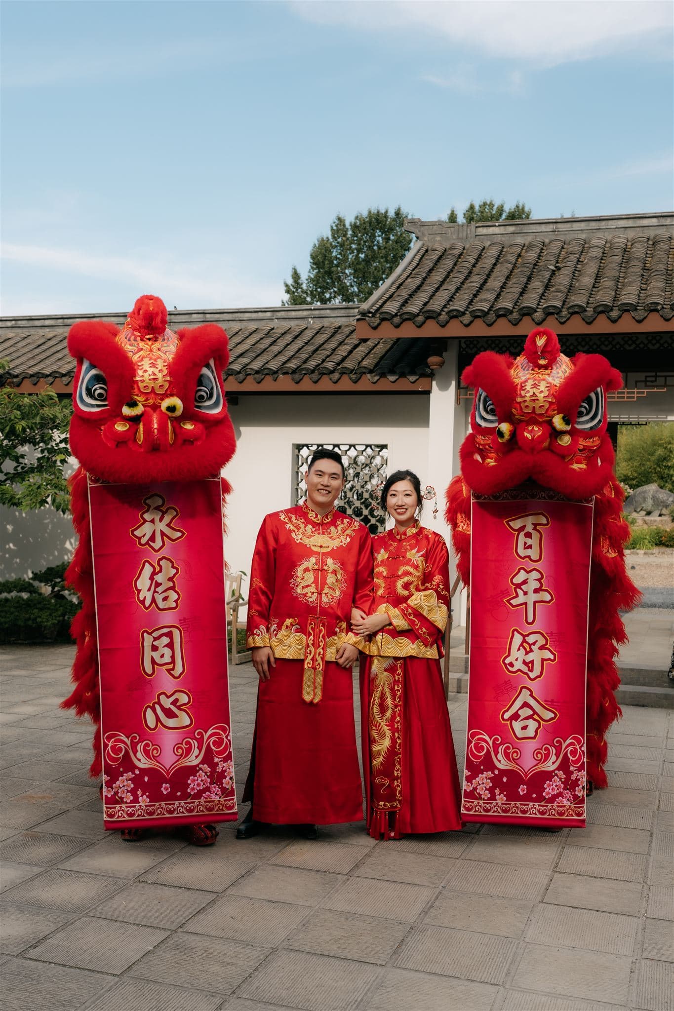Couple wears traditional red Chinese wedding attire after their lion dancing wedding ceremony.