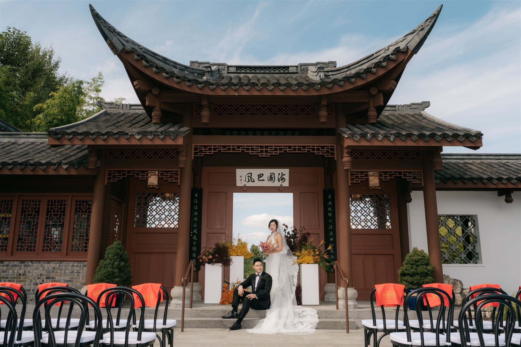 Bride and groom stand under an arch at Seattle Chinese Garden wedding venue.