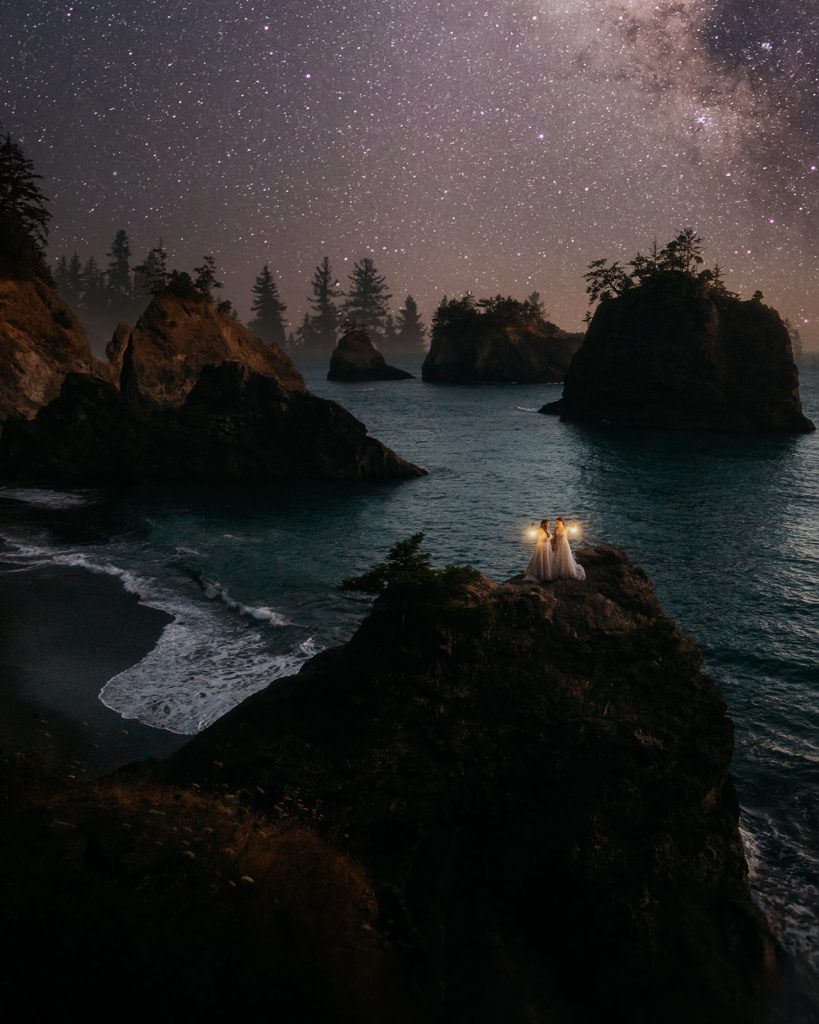 Two brides stand on a rock overlooking the ocean during their Oregon Coast elopement. This photo won Best of Wedding Photo by Junebug weddings