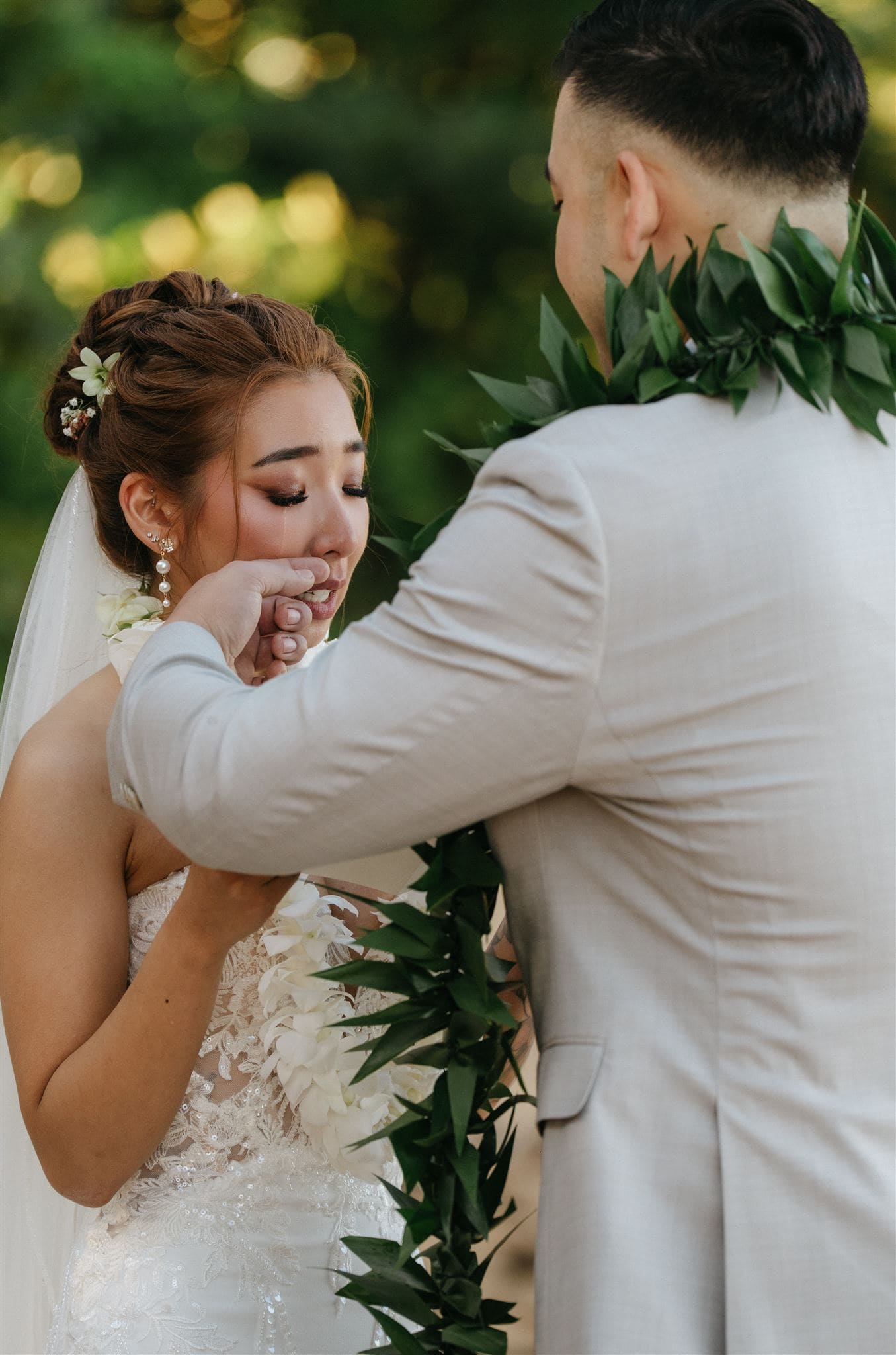 groom wipes his bride's tears during their wedding ceremony