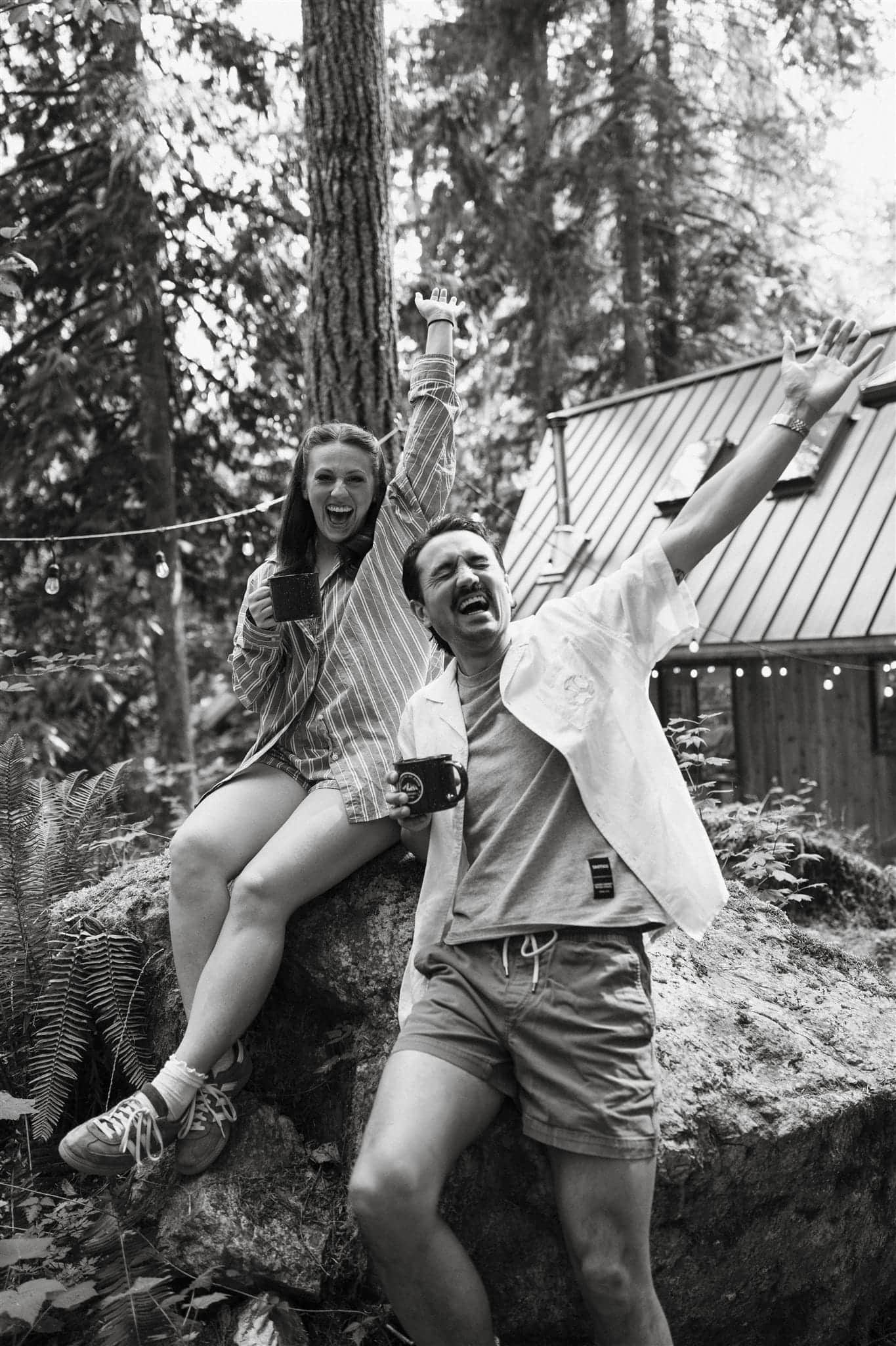 Couple cheers while lounging on the patio of their A-frame cabin near Mt Baker.