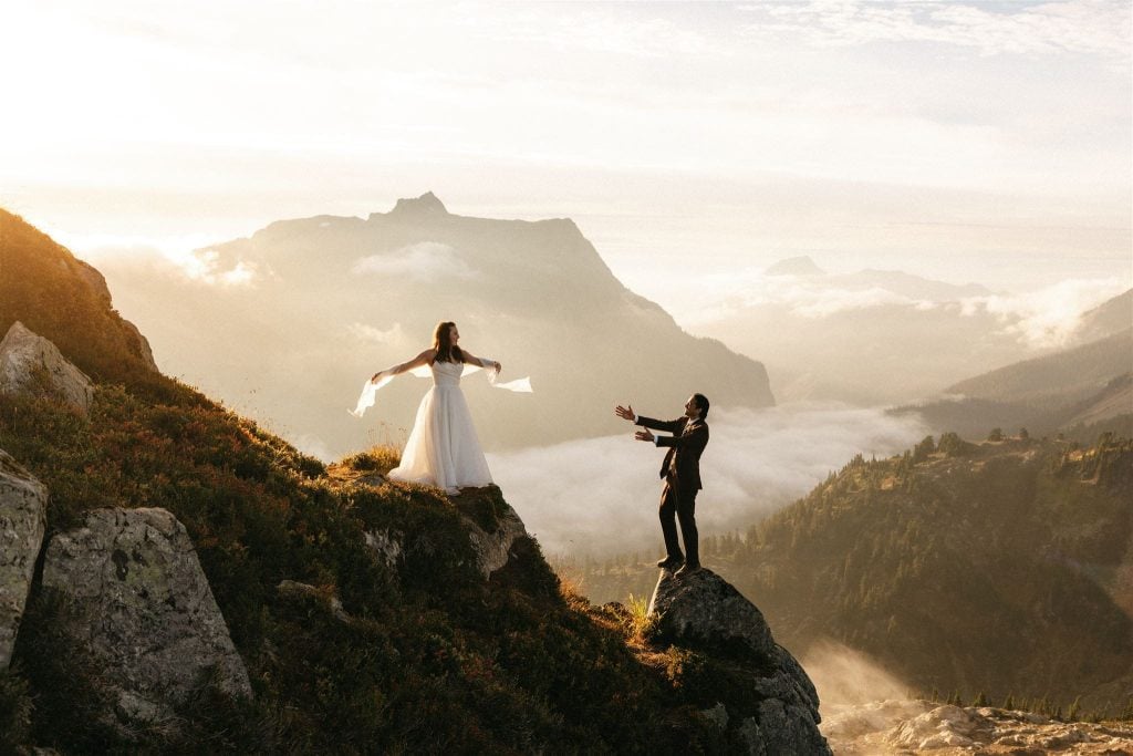 Couple stands on the edge of a mountain during their sunset Mt Baker elopement portraits.
