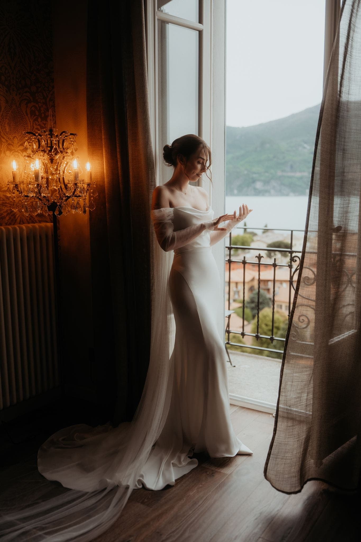 Film wedding photo of bBride leans against a doorframe in her villa overlooking Lake Como.