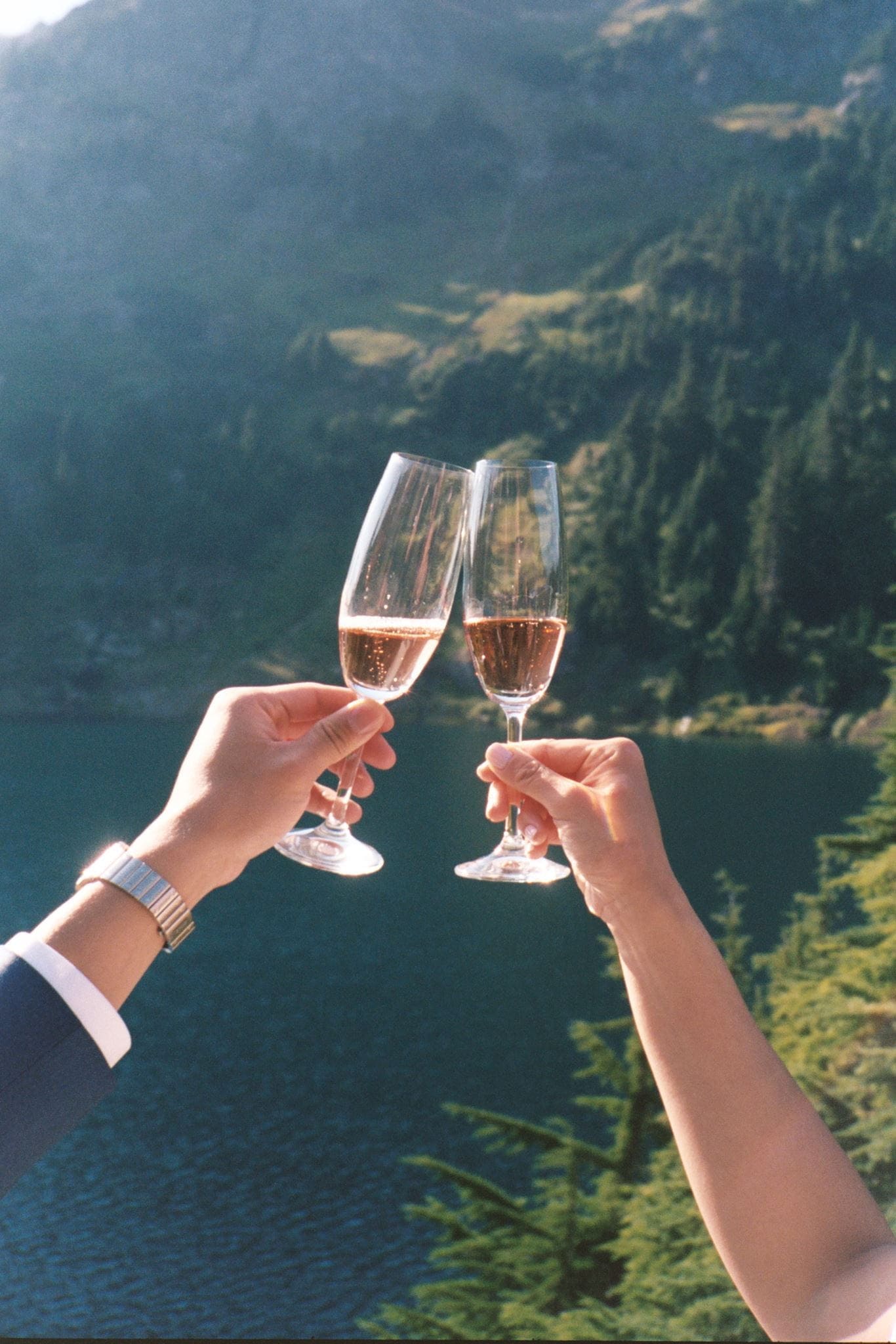 Newlyweds toast champagne at an alpine lake in Washington State.