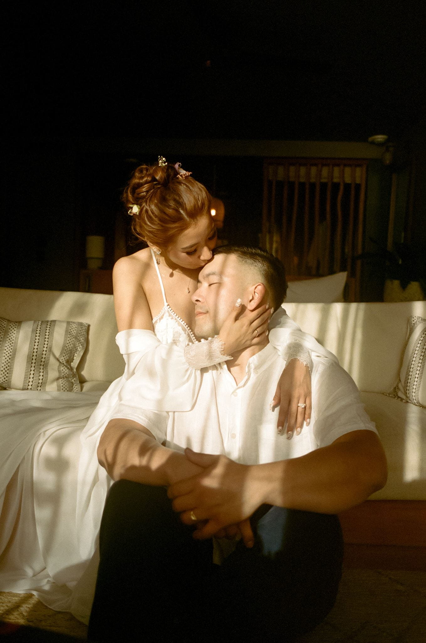 Bride and groom hug in their hotel room during their Hawaii wedding documented on film.
