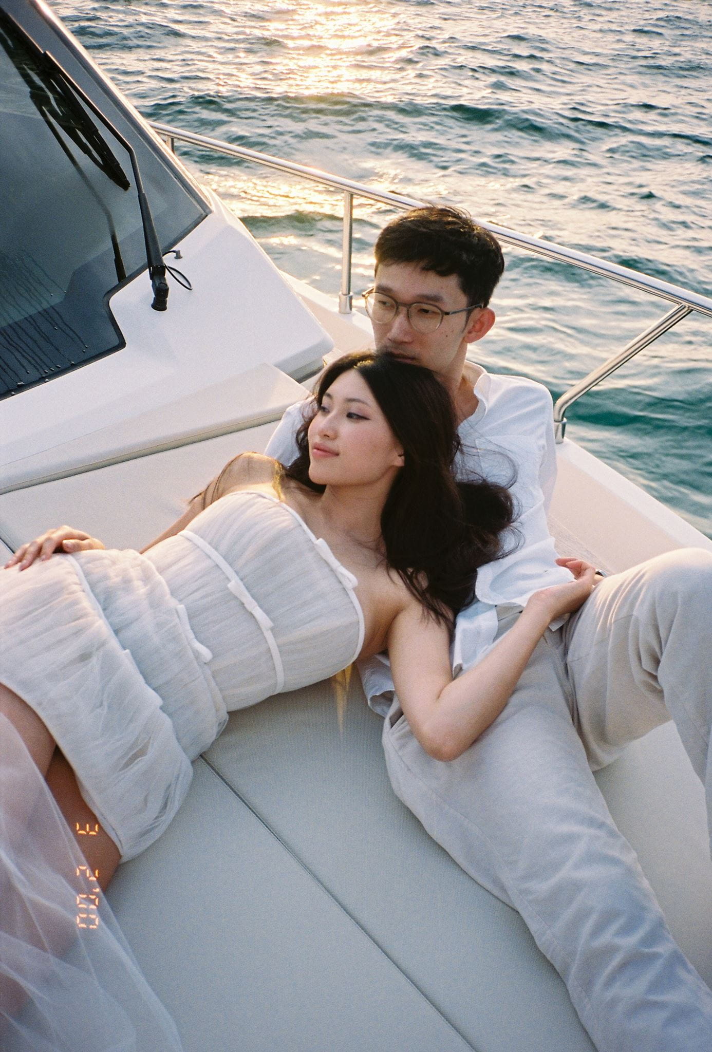 Couple lounges on a boat in Vietnam during their film engagement photos.