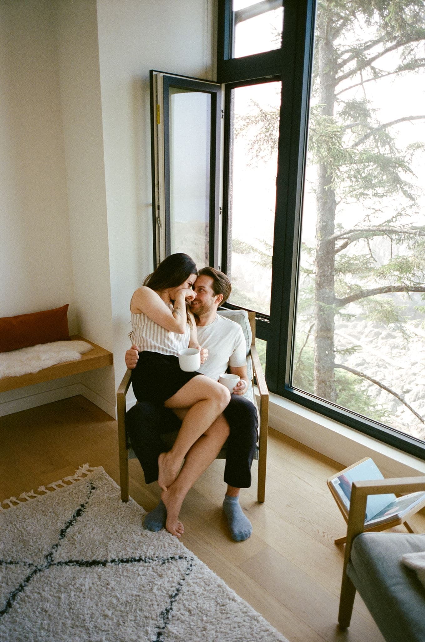Couple cuddles on a living room trail during their intimate film photo session.