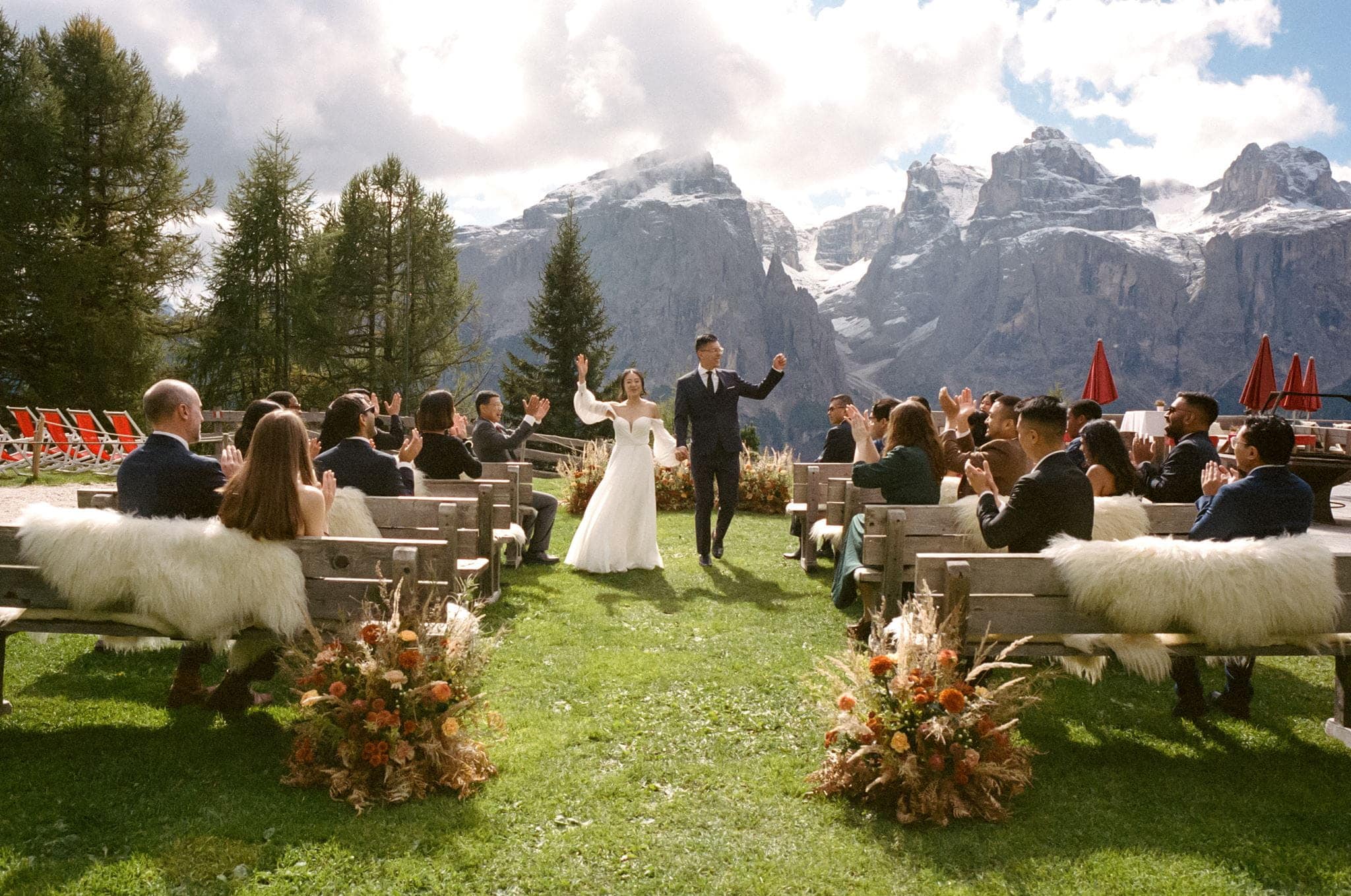 Bride and groom wave at their guests after their Italy mountain wedding documented on film.