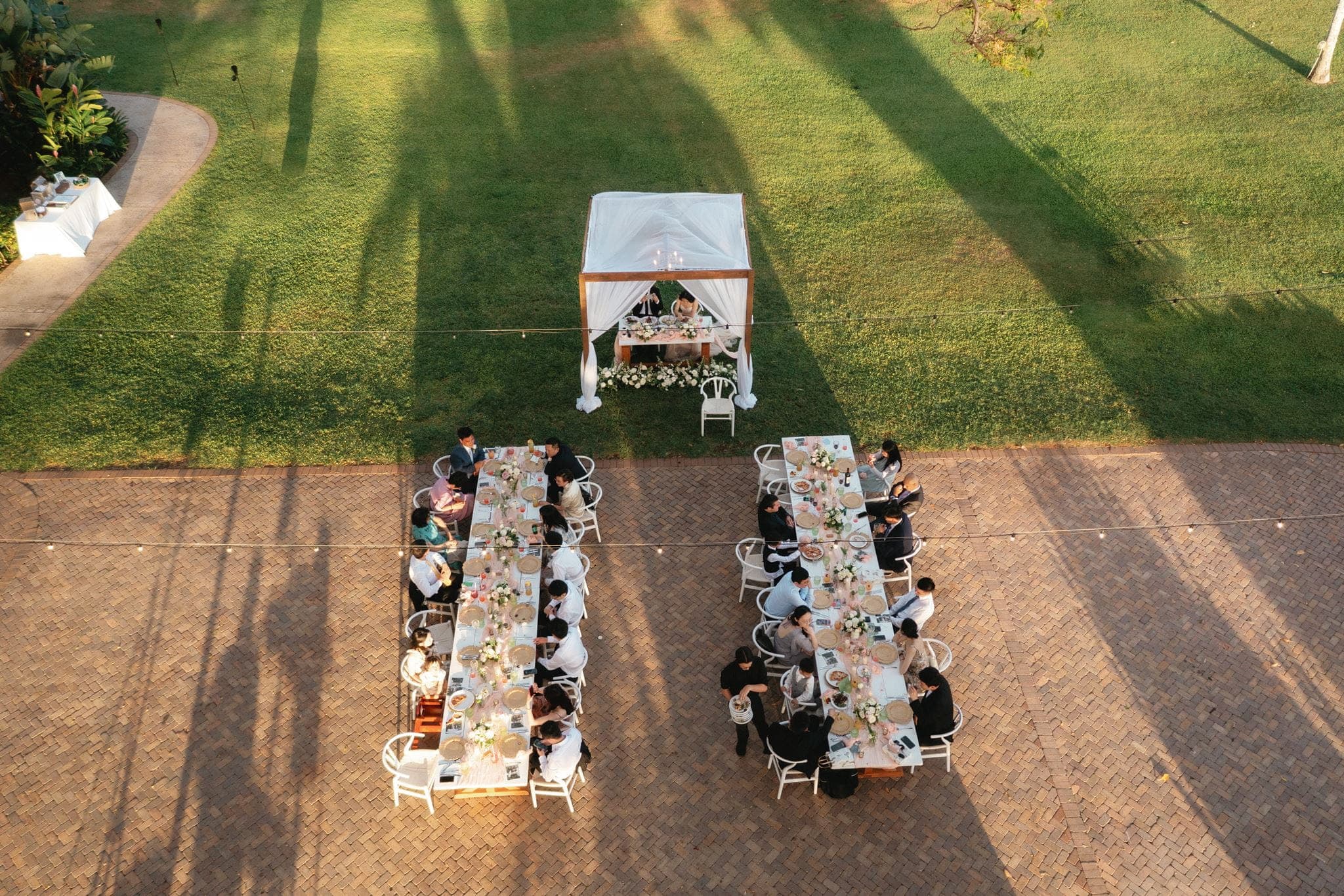 Guests sit at two rectangle tables during a wedding reception dinner at Olowalu Plantation House.