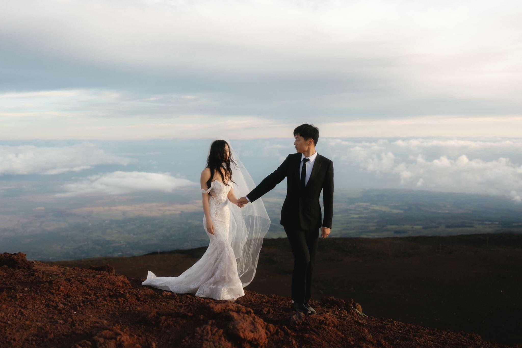 Bride and groom walk Haleakalā Summit at sunrise during their two day Maui wedding.