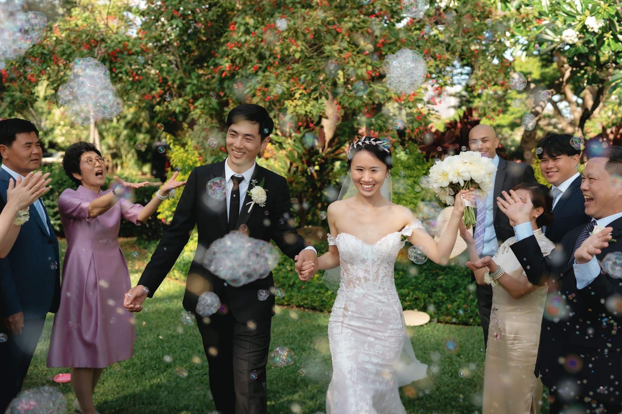Guests blow bubbles while newlyweds exit after their Olowalu Plantation House wedding ceremony.