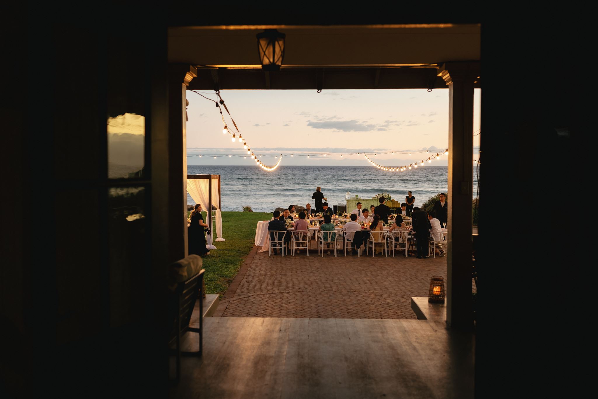 Guests dine at an Olowalu Plantation House micro wedding reception by the beach.