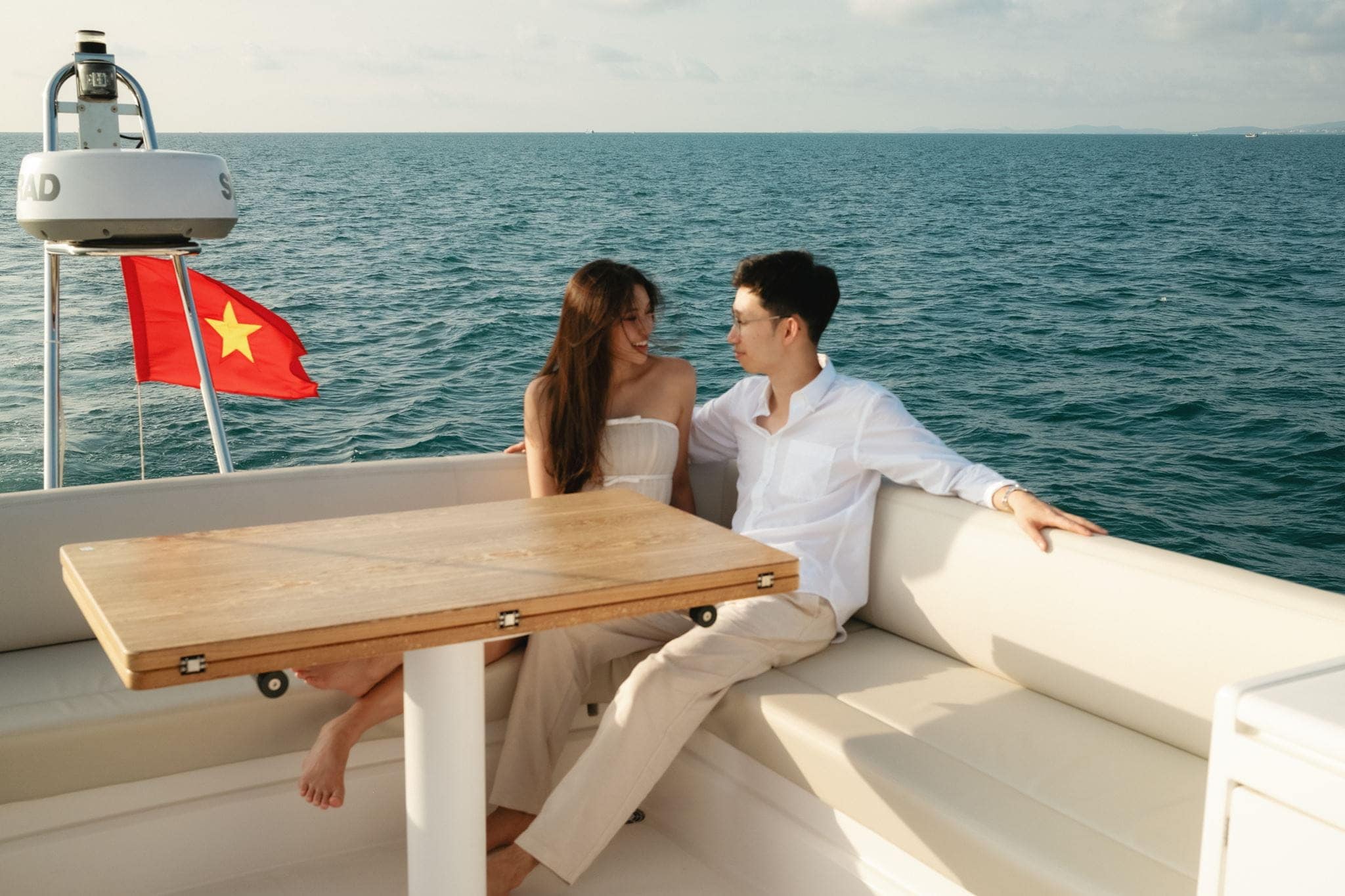 Couple lounges on a boat during their destination engagement session in Vietnam.