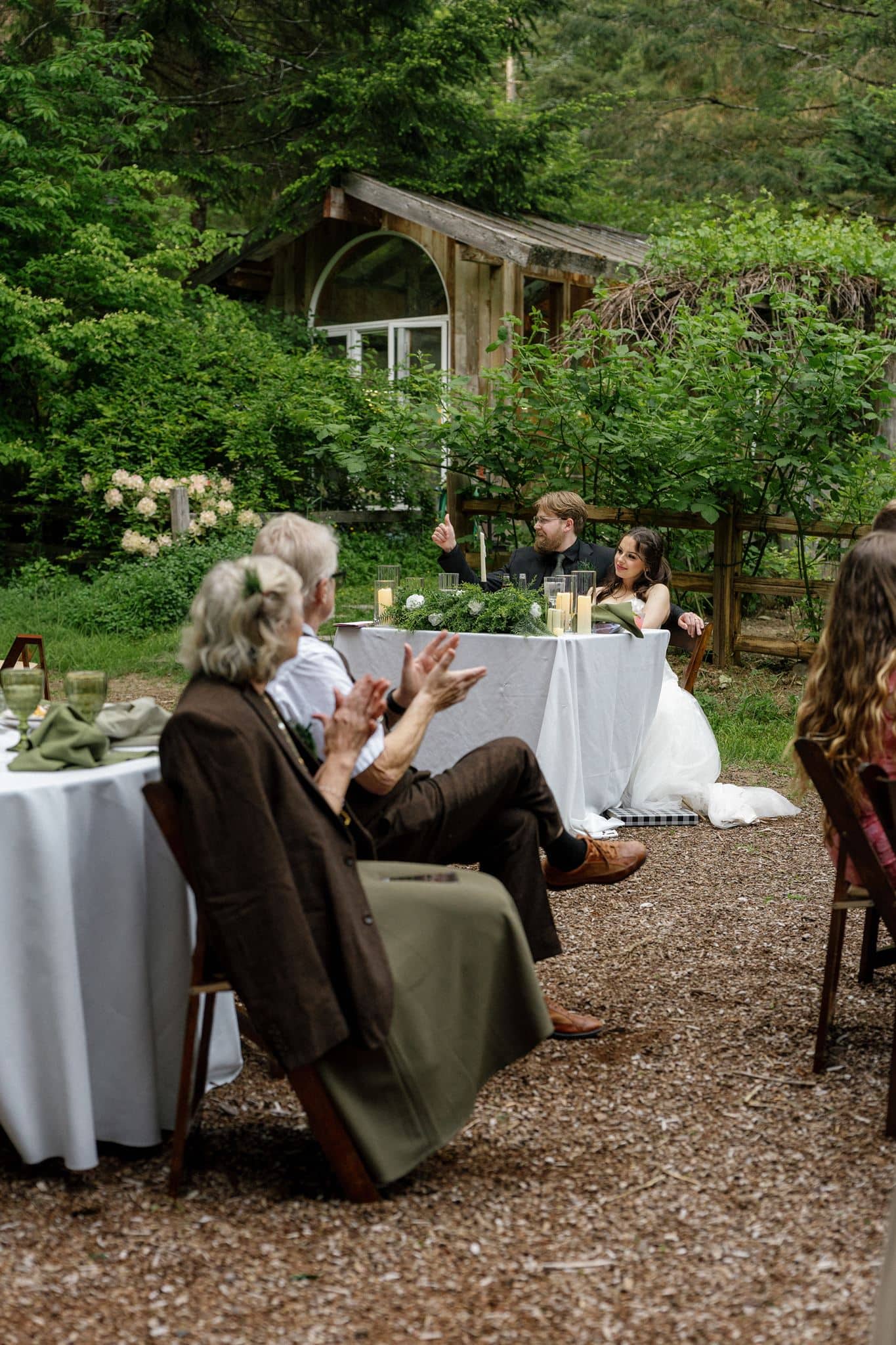 Guests clap during a reception dinner at Wellspring Spa, a Washington micro wedding venue near Mt Rainier.