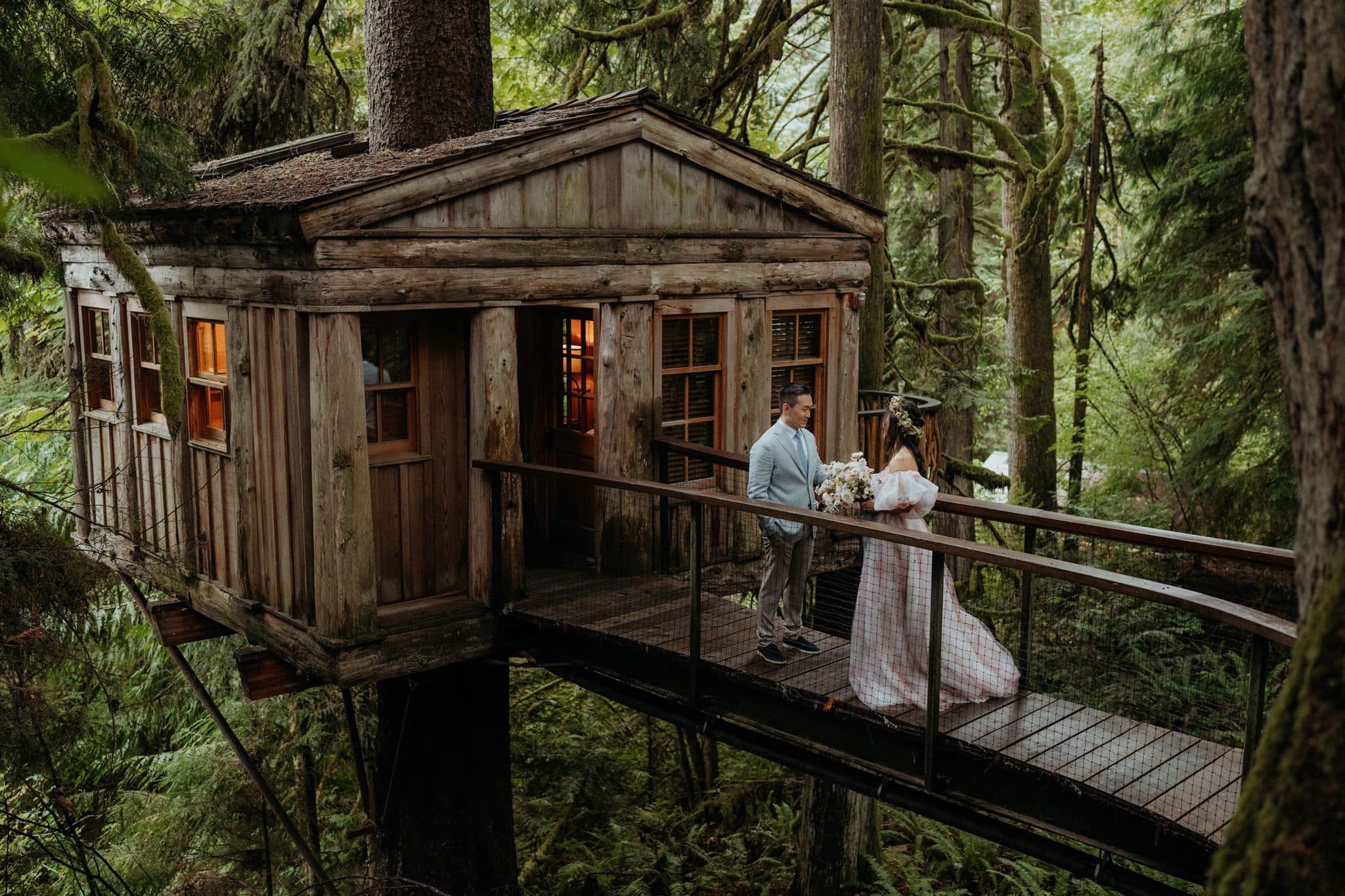 Newlyweds dance on a suspension bridge at Treehouse Point in Snoqualmie, WA.