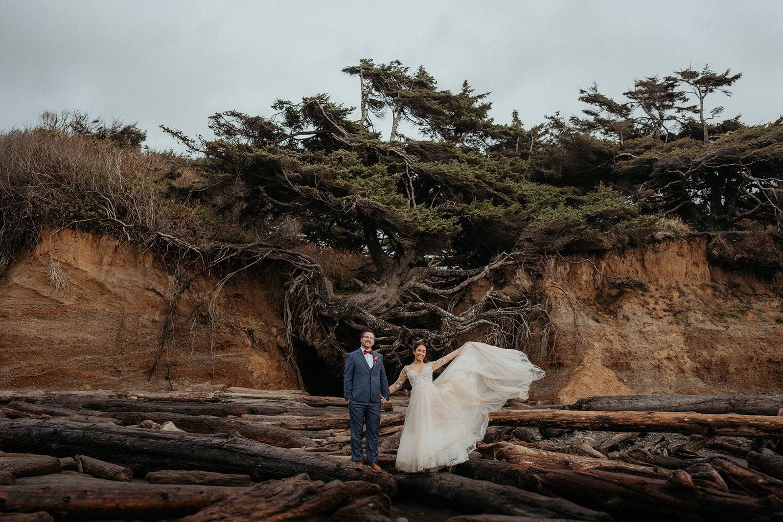 Newlyweds stand in front of the Tree of Life on the Olympic Coast.