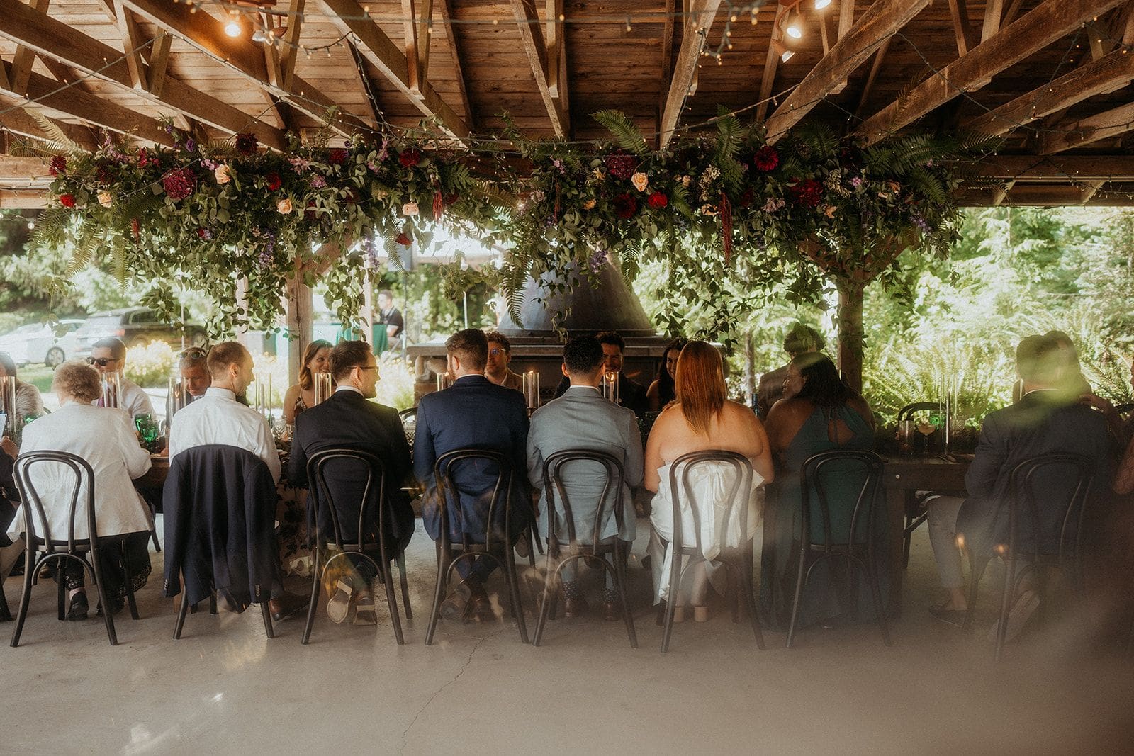 Guests sit around a long rectangle table during a reception meal at Wandering Waters Farm.