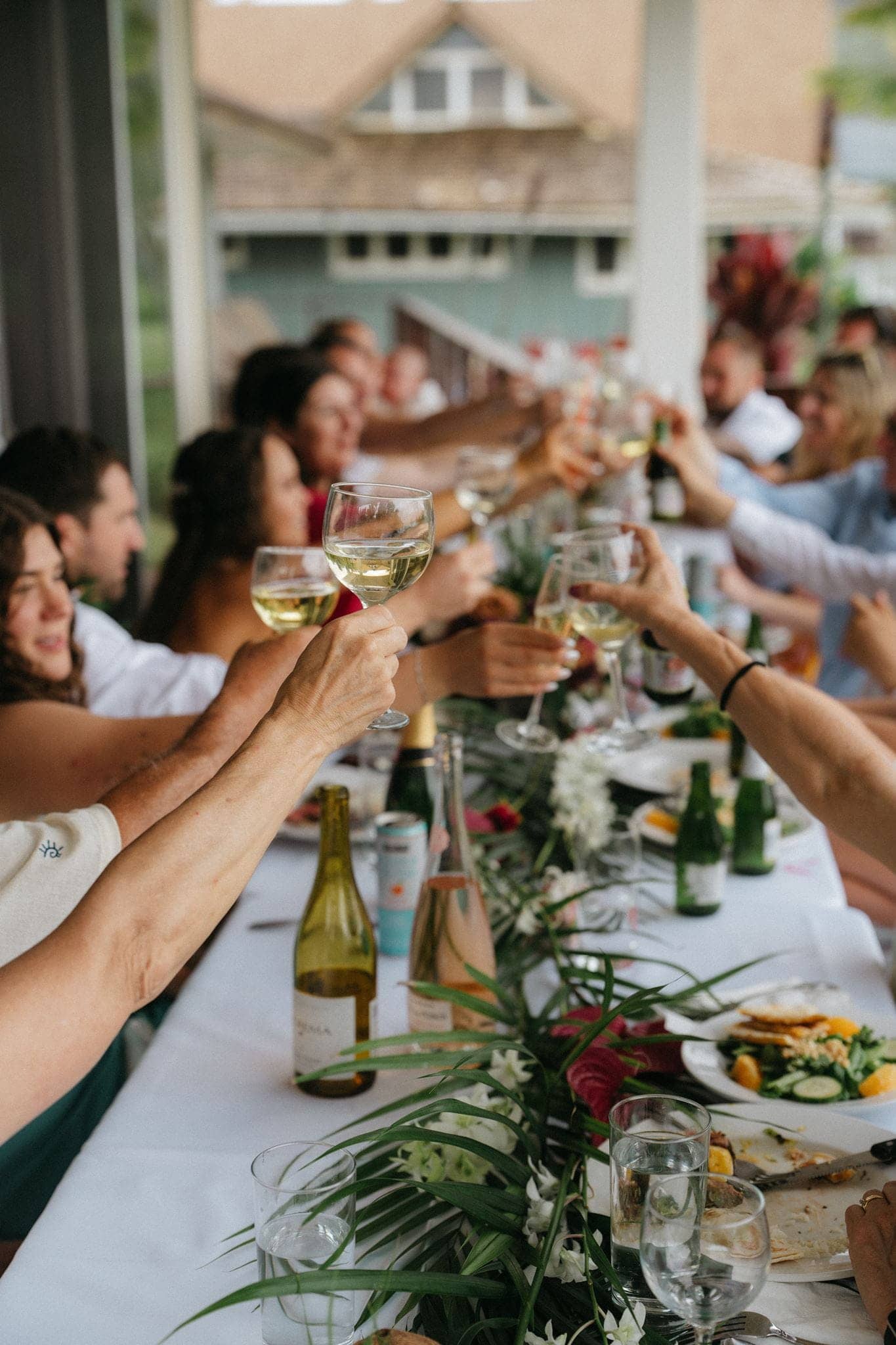 Guests toast at a micro wedding reception dinner at an Airbnb in Hawaii.