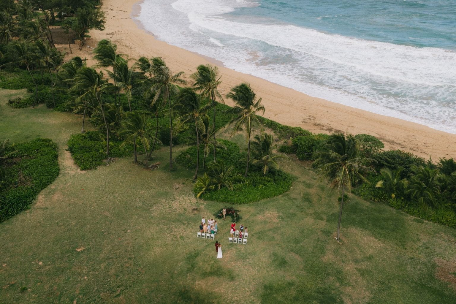Bride walks down an outdoor wedding aisle during a micro wedding ceremony in Kauai, Hawaii.