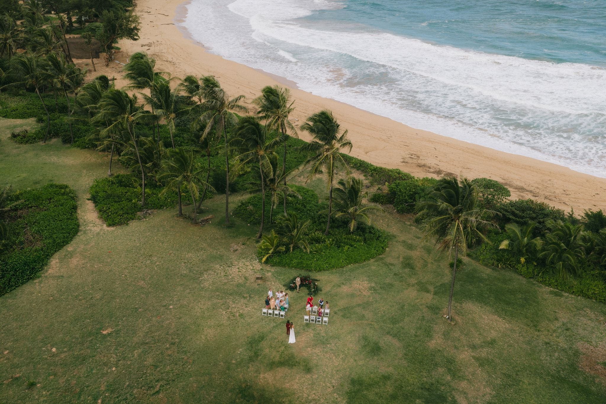 Bride walks down an outdoor wedding aisle during a micro wedding ceremony in Kauai, Hawaii.